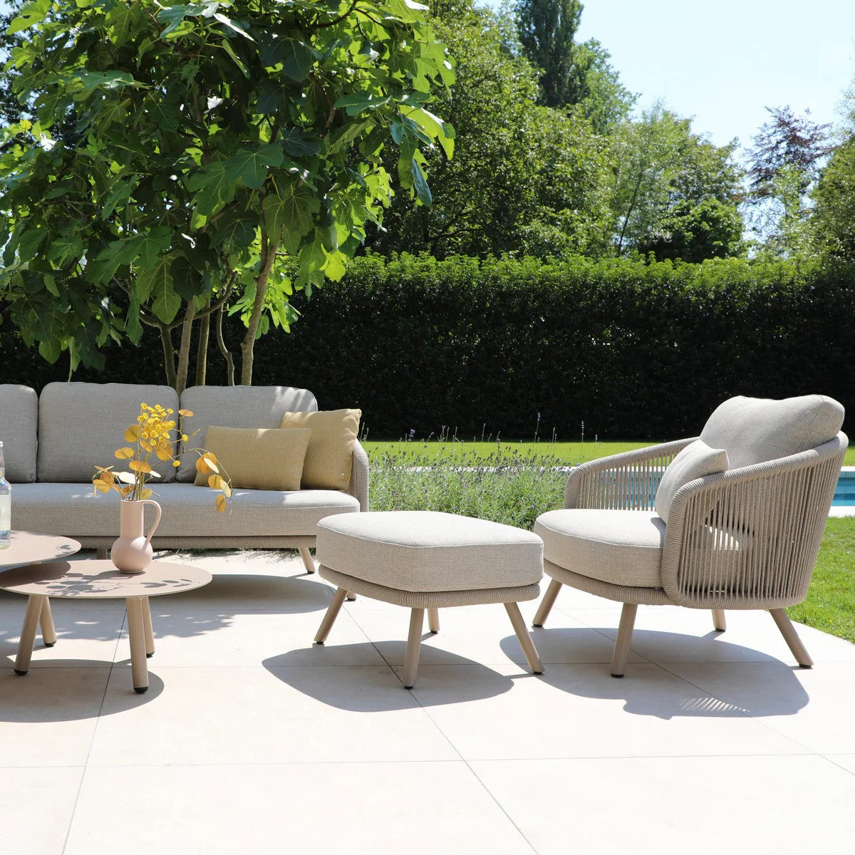 Modern dining set with a long white table and eight beige cushioned chairs on a white background.