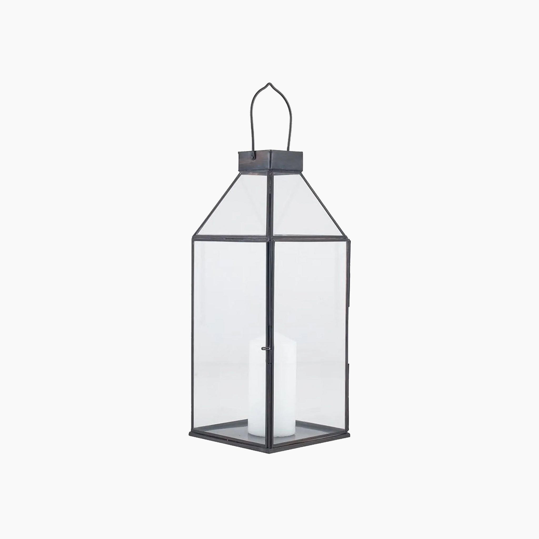 A tall decorative lantern with a black metal frame and clear glass panels containing a white candle inside.