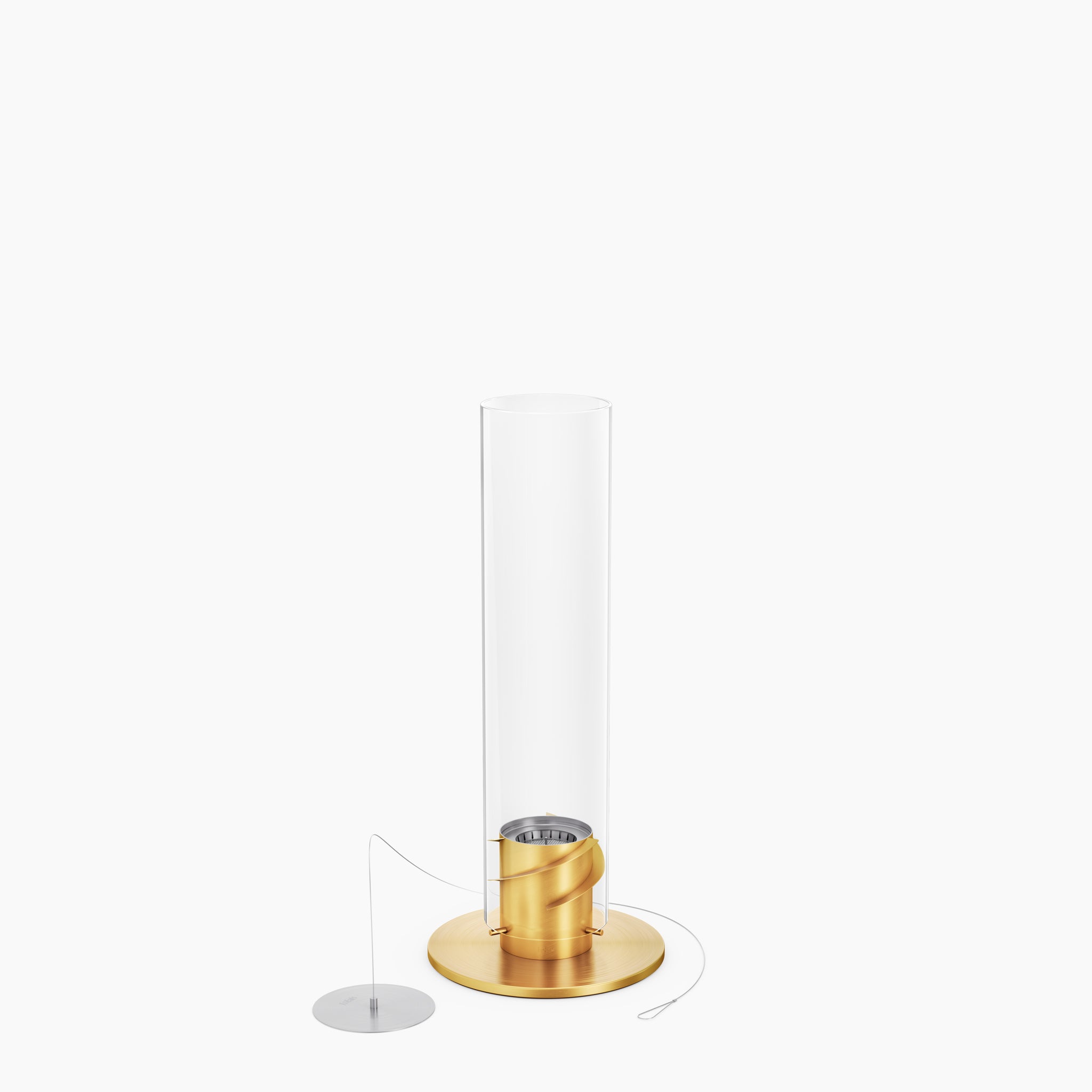 The Höfats SPIN 900 Tabletop Fireplace in gold, featuring a decorative glass cylinder, a flat metal disc as its base, and a thin cable attached for stability, creates an elegant look.