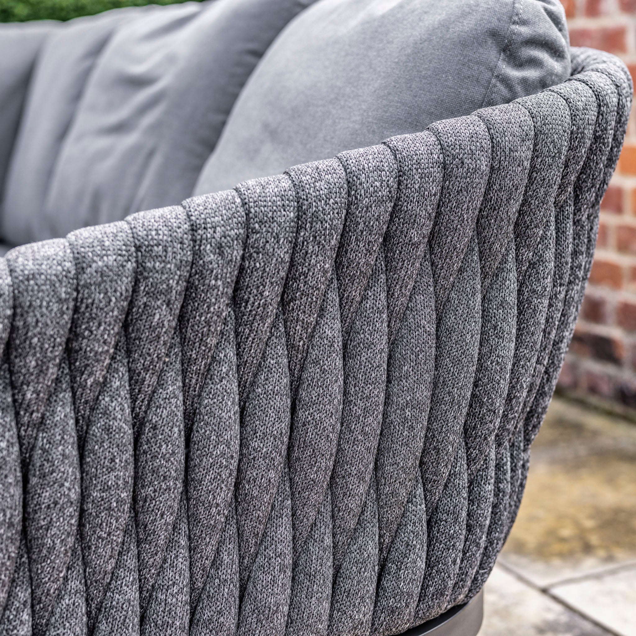 Close-up of a textured grey fabric sofa armrest with a tufted, wavy pattern, part of the UV-resistant Palma 3 Seat Rope Sofa Set with Rising Table in Grey.