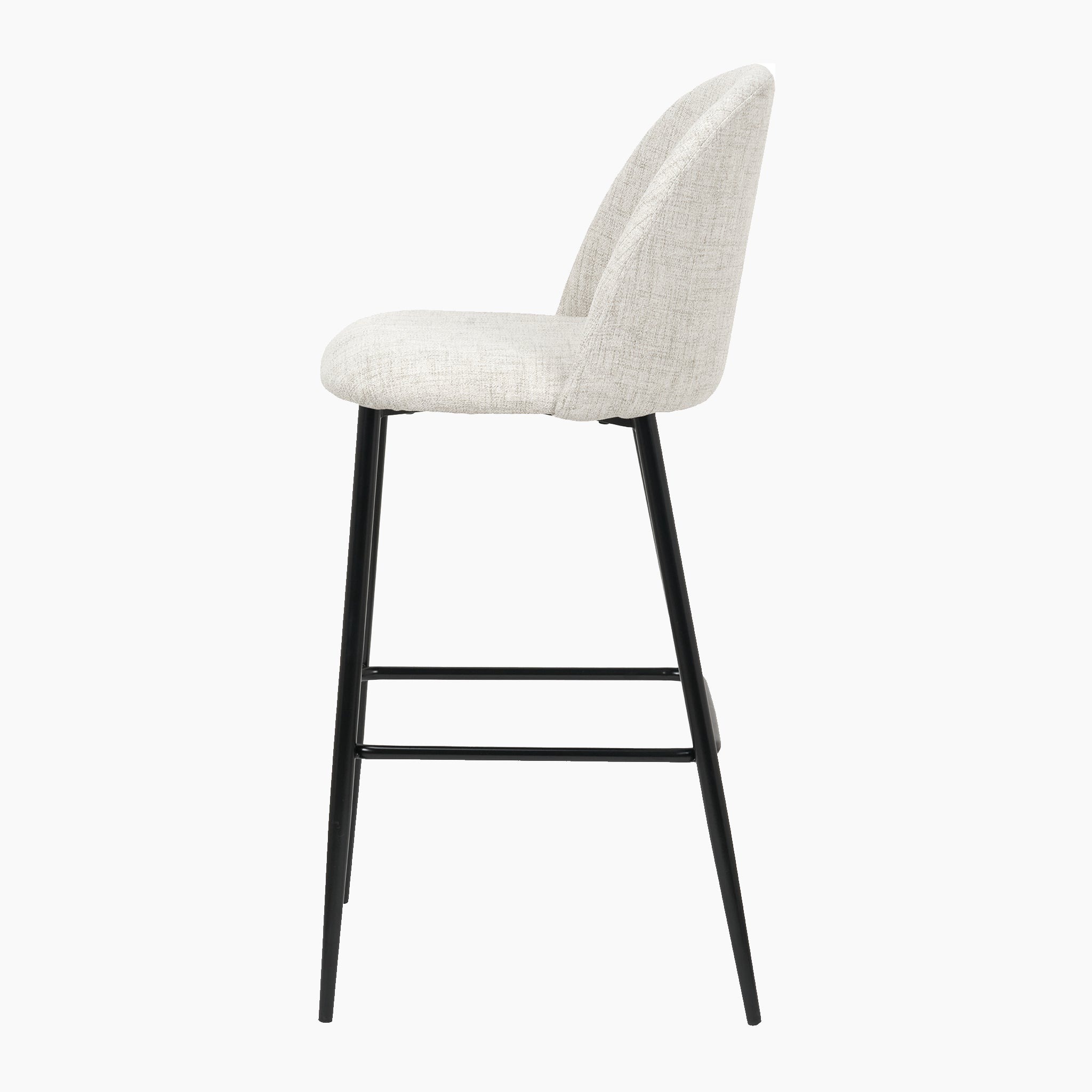 Side view of the Turi Pebble Linen Mix and Black Metal Bar Stool, boasting a contemporary design with a light grey cushioned seat and backrest, black metal legs, and a footrest bar.