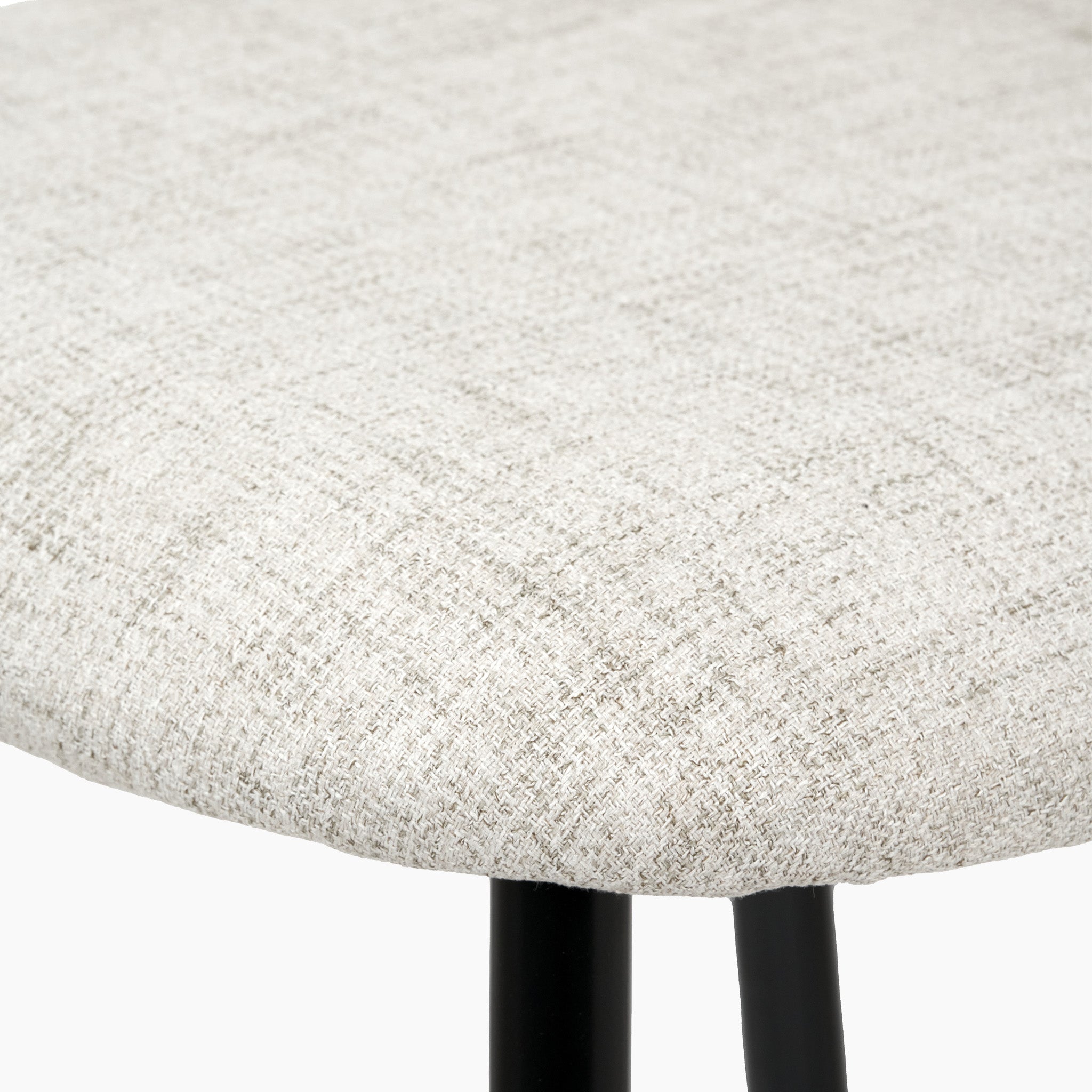 Close-up of a Turi Pebble Linen Mix and Black Metal Bar Stool seat, featuring a contemporary light grey fabric cover and black metal legs, perfectly embodying the modern style.