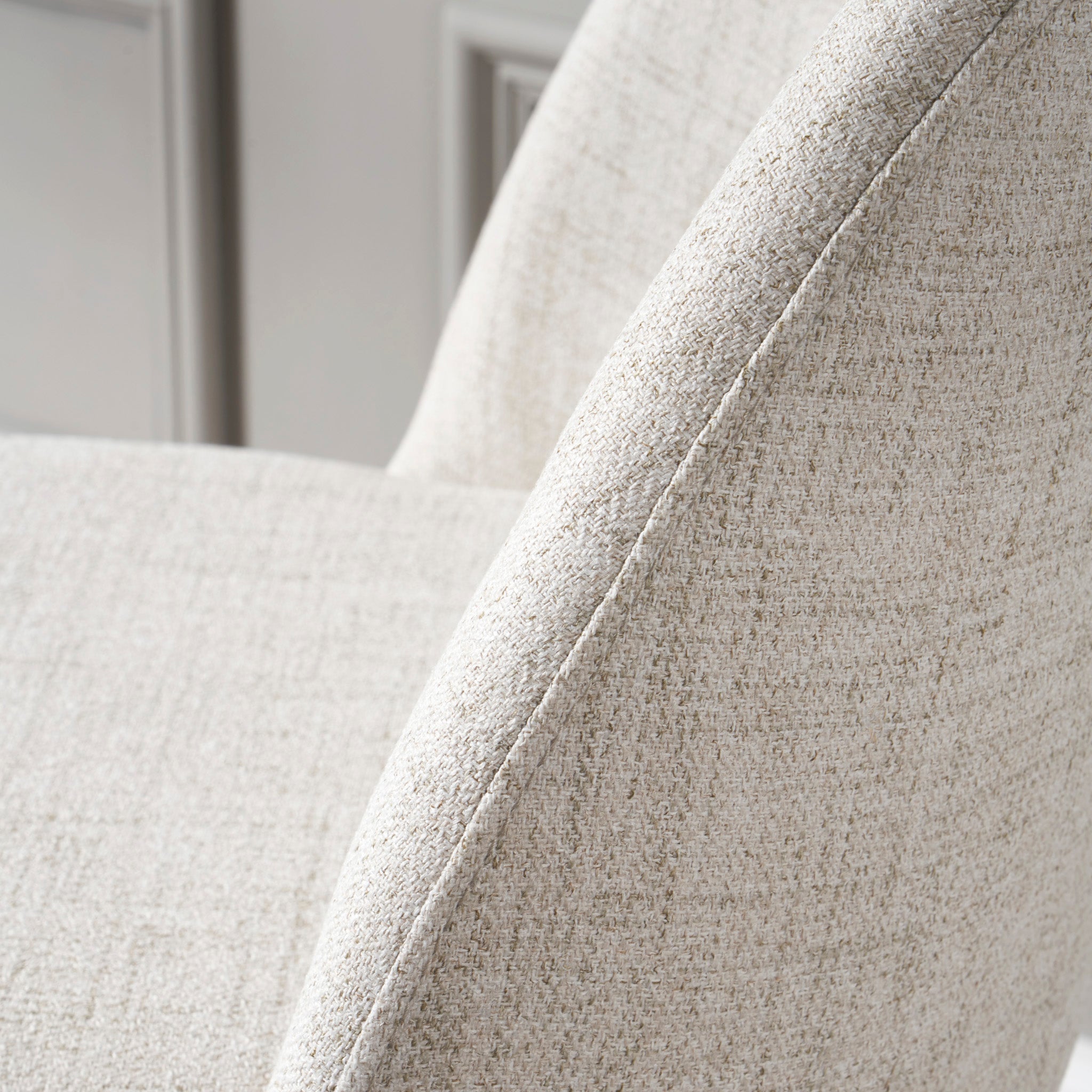 Close-up of the Turi Pebble Linen Mix and Black Metal Bar Stool, featuring a light beige upholstered seat with visible stitching and textured fabric, embodying a modern style that complements any contemporary space.