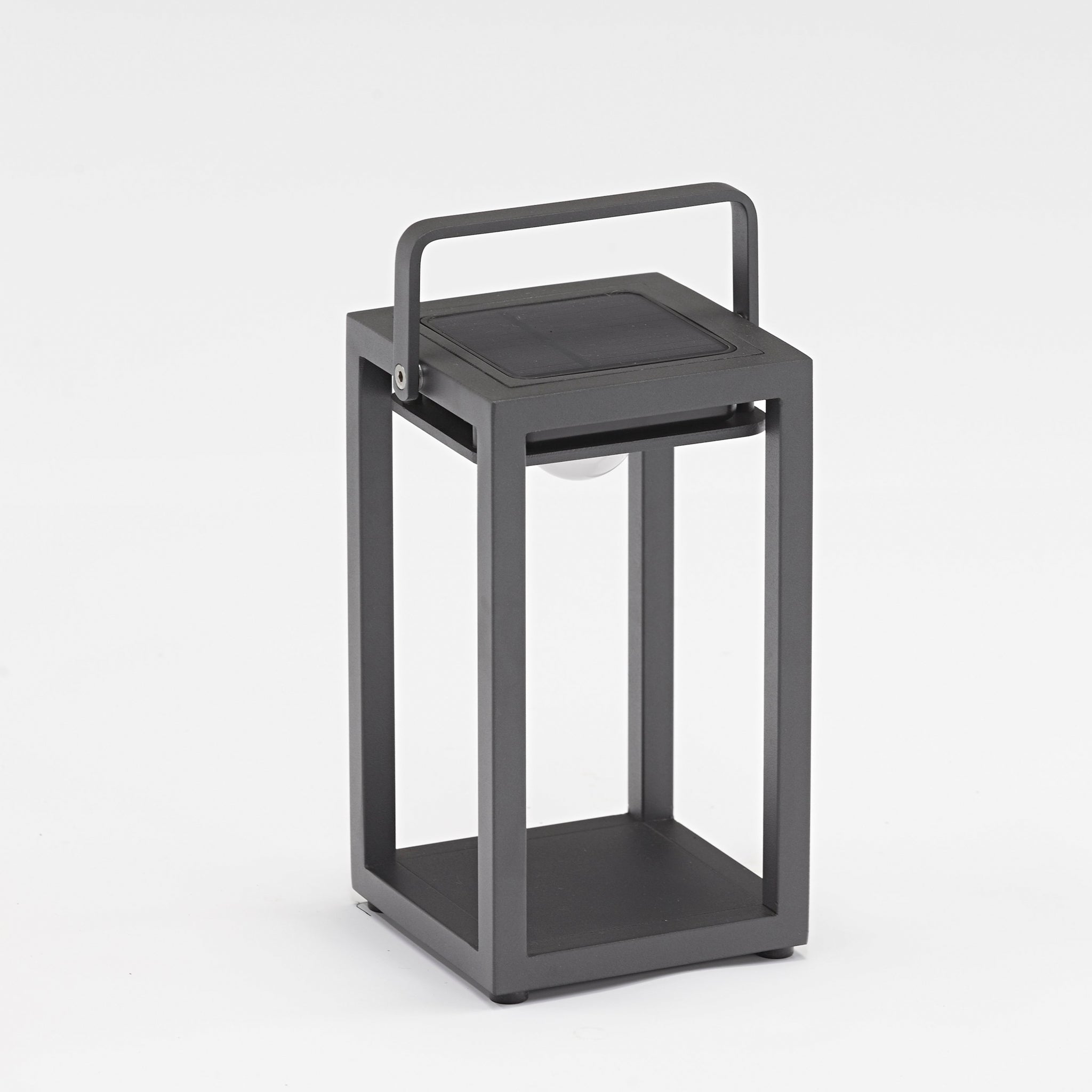 The Luxor Small Table Outdoor and Indoor Solar Lantern in Charcoal is a modern, black metal lantern with a handle, featuring an open rectangular design and solar lighting, placed on a white background.