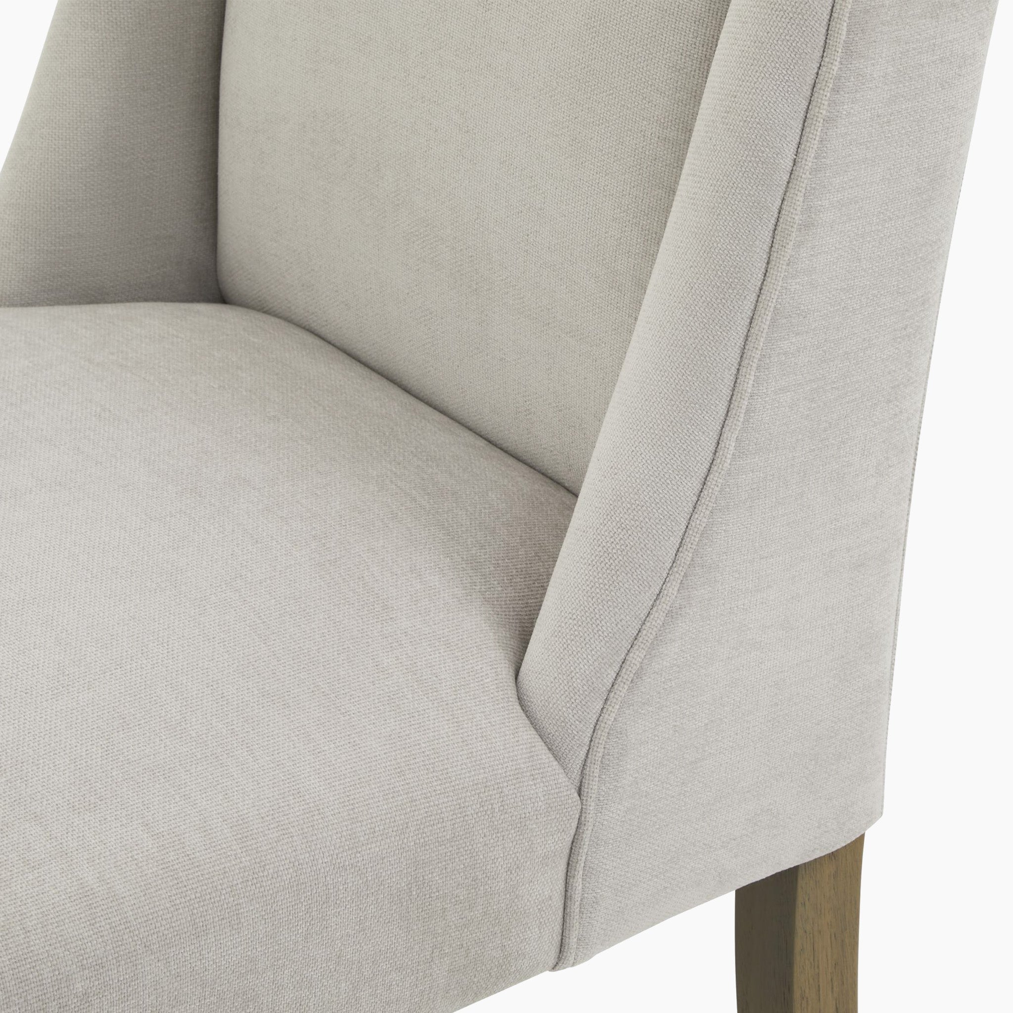 Close-up of the Kingham Grey Dining Chair, showcasing its woven fabric upholstery and durable rubberwood legs.