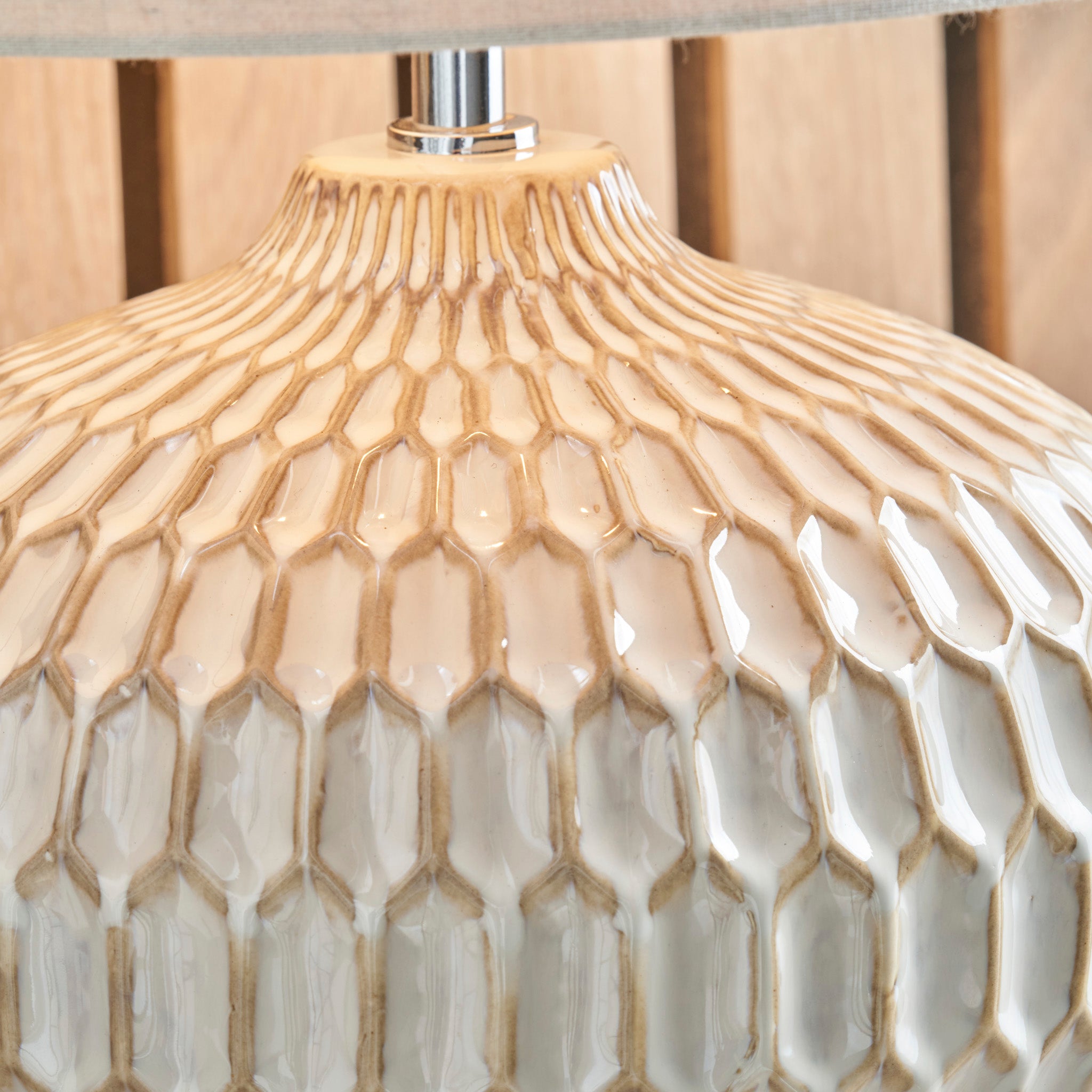 Close-up of the Cassius Warm White Textured Glazed Ceramic Table Lamp, featuring a honeycomb pattern in beige and white tones and paired with an elegant linen lampshade.