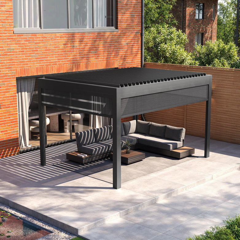 Enhance your outdoor living with a PergoSTET Deluxe 3m x 4m pergola featuring motorised LED louvres and grey manual side blinds, set beside a brick wall with a gray sectional sofa and coffee tables on a concrete patio.