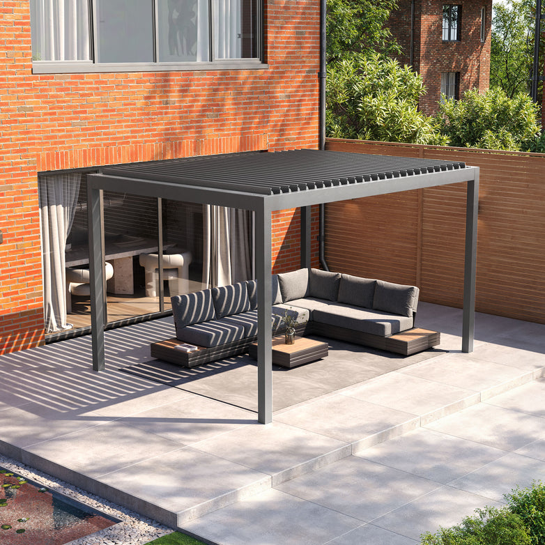 The patio features the PergoSTET Deluxe 3m x 4m Pergola, with motorised LED louvres, providing cozy seating against the brick house and enhanced by subtle lighting.