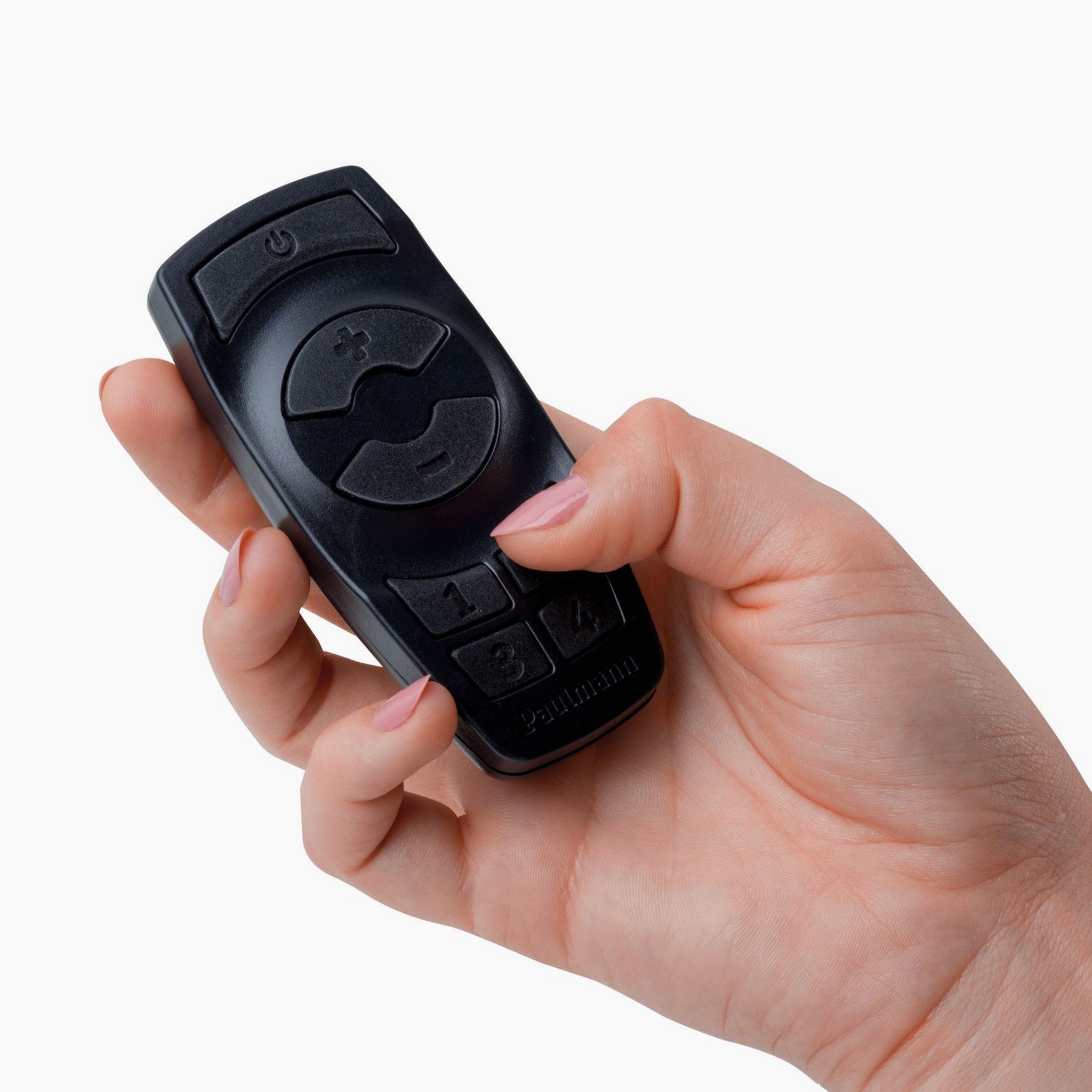 A hand holding the Paulmann - Plug & Shine Outdoor Wireless Controller with Remote in Black, featuring numbered and arrow buttons, ideal for enhancing your outdoor lighting experience.