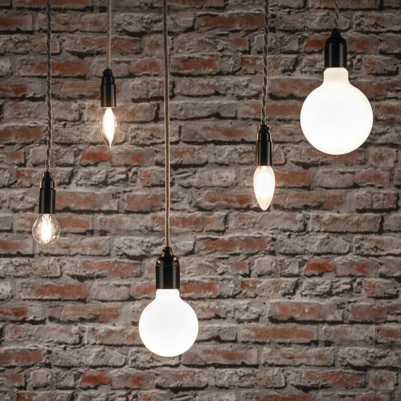 Paulmann's Filament LED Drop Bulbs, designed with a 2.6W E14 base, hang in front of a textured brick wall, casting an eye-friendly warm white light.