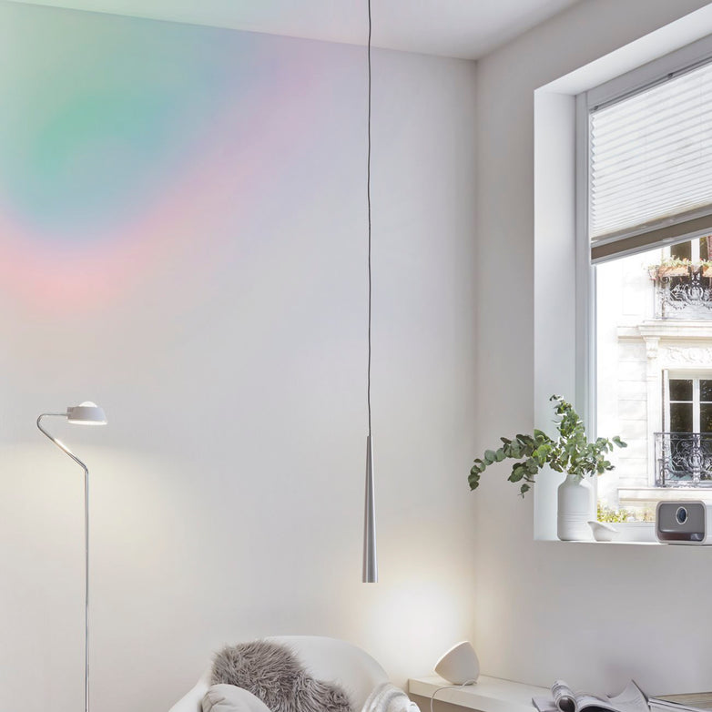 Minimalist room with white walls, a floor lamp, a Gutta 8.5W LED Dimmable 1 Lamp Pendant Light in Brushed Aluminium showcasing a focused lighting effect, a small window, and a potted plant on the sill.