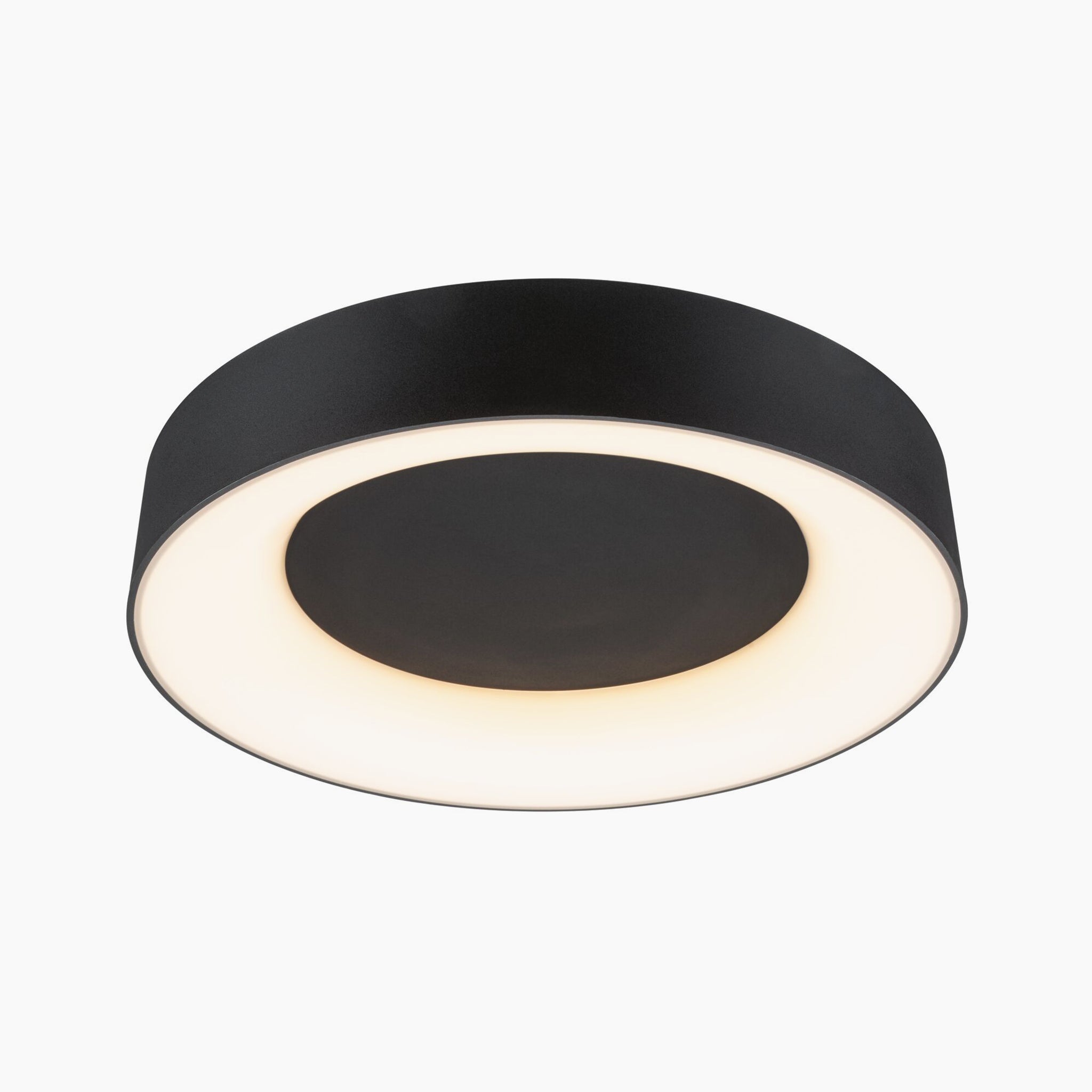 The Casca 25W LED Switch 2100lm Ceiling Light in Black Matt showcases a round, modern design with a sleek black outer ring and a radiant inner circle on a white background. This versatile fixture provides adjustable light color for customizable lighting effects.