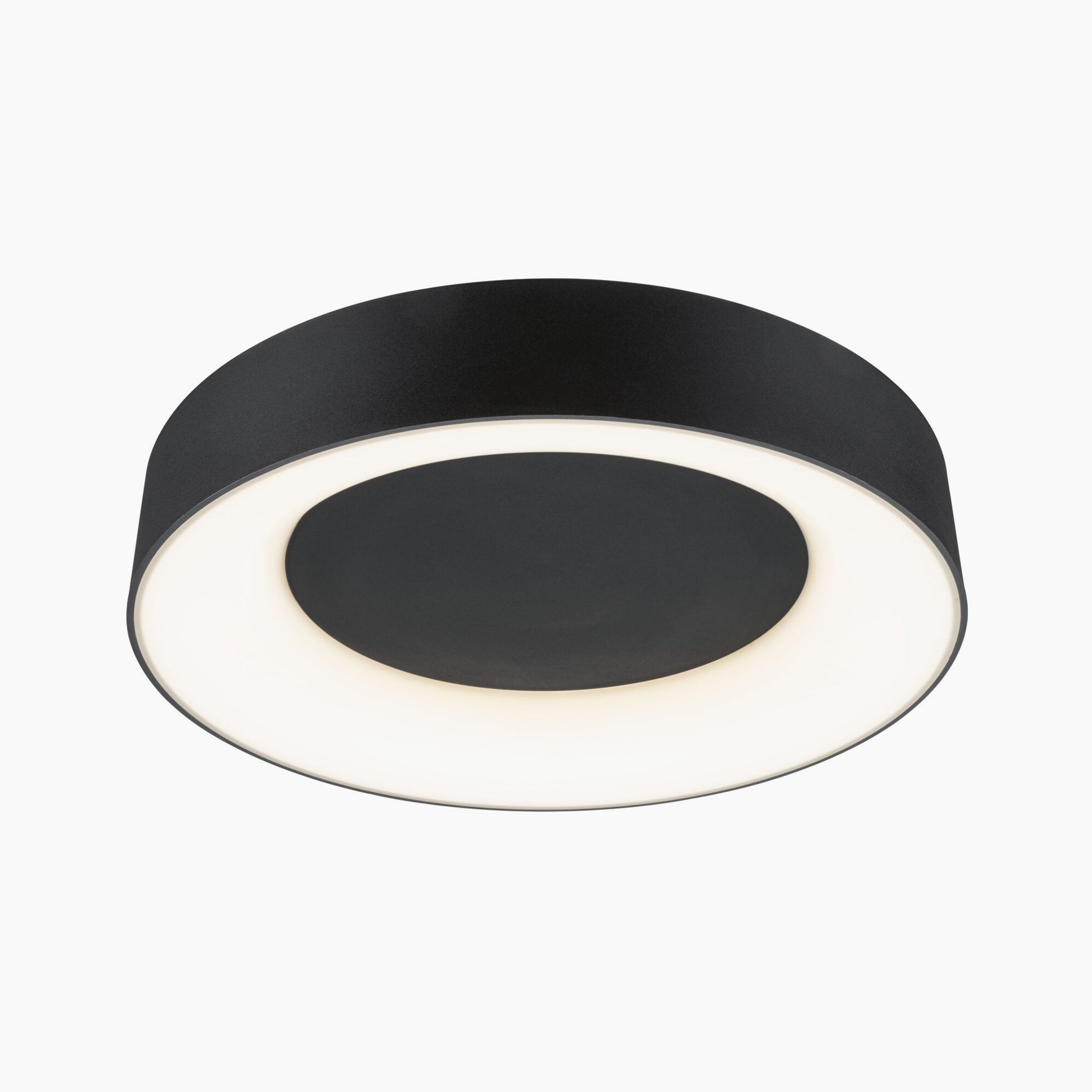 The Casca 25W LED Switch 2100lm Ceiling Light in Black Matt features a sleek, circular flush-mount design with a central dark disk encircled by a glowing white ring. Its adjustable light color allows for versatile lighting effects to suit any mood or setting.