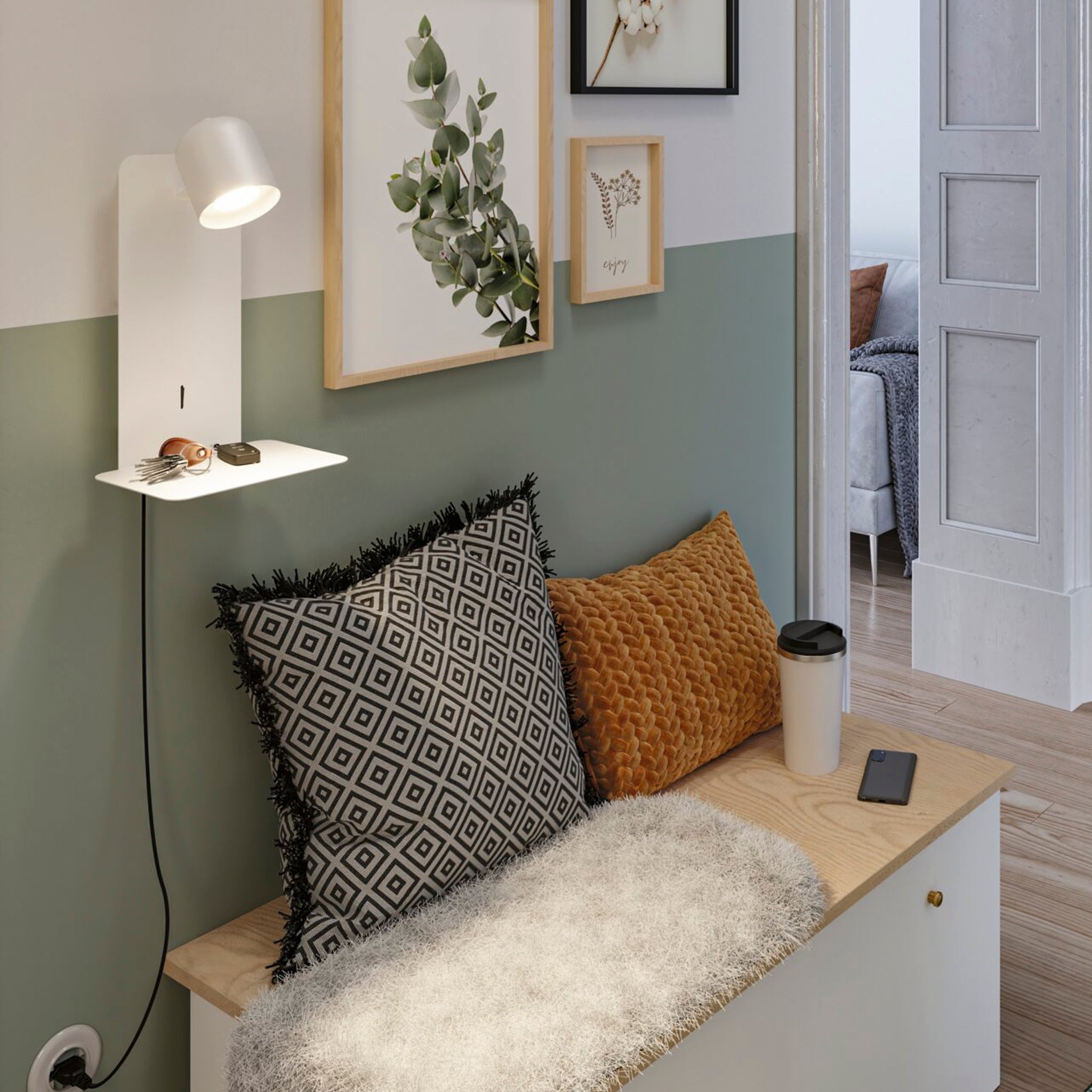 A cozy nook featuring patterned pillows, wall art, and a small lamp with the flexible luminaire head of the Paulmann - Malena 5W Wall Light with USB Charging Port in White Matt. A coffee cup sits beside it, ready for use. The room's light green and white walls enhance the ambiance while the USB Type-C charging port offers modern convenience.