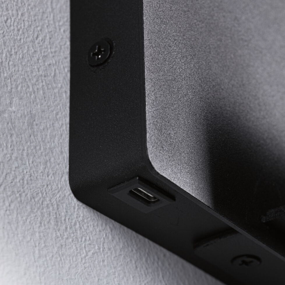 Close-up of a black rectangular Halina 3.5W LED Wall Light with USB Charging Port in Black Matt, featuring a USB Type-C charging socket and screws.