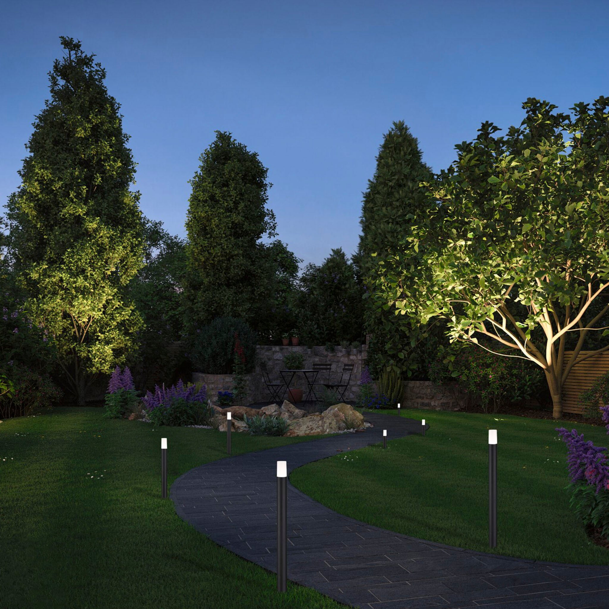 A tranquil garden pathway lit by small lights at dusk, enhanced by the subtle glow of an LED Garden RGBW Spotlight, powered by the Paulmann - Plug & Shine Outdoor 150VA Power Supply Transformer in White, surrounded by lush trees and plants.