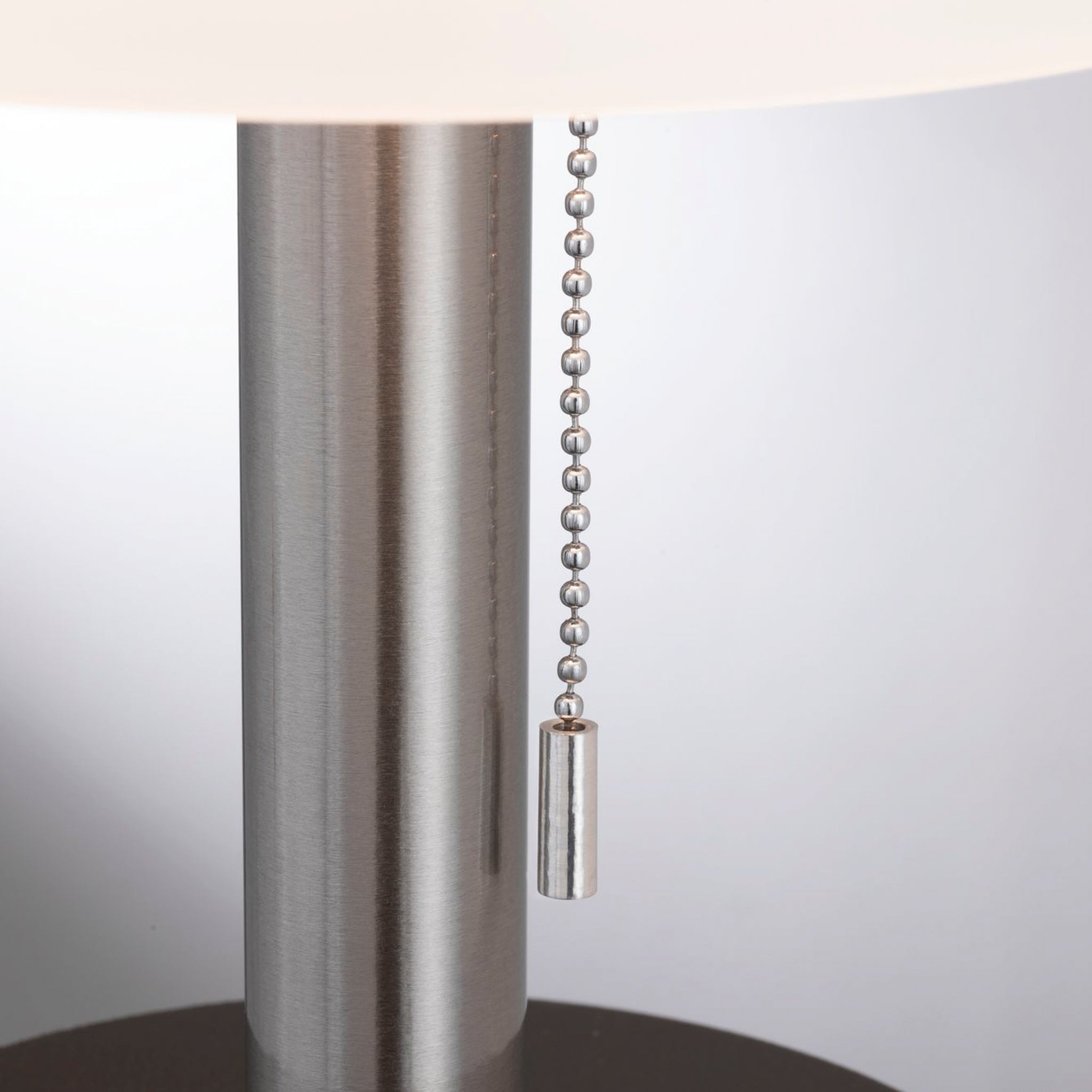 Close-up of an Outdoor Lillesol 0.8W LED Solar Table Lamp with a 3-Step Dim feature in stainless steel, featuring a modern design and metallic pull chain switch hanging from the lamp's body.