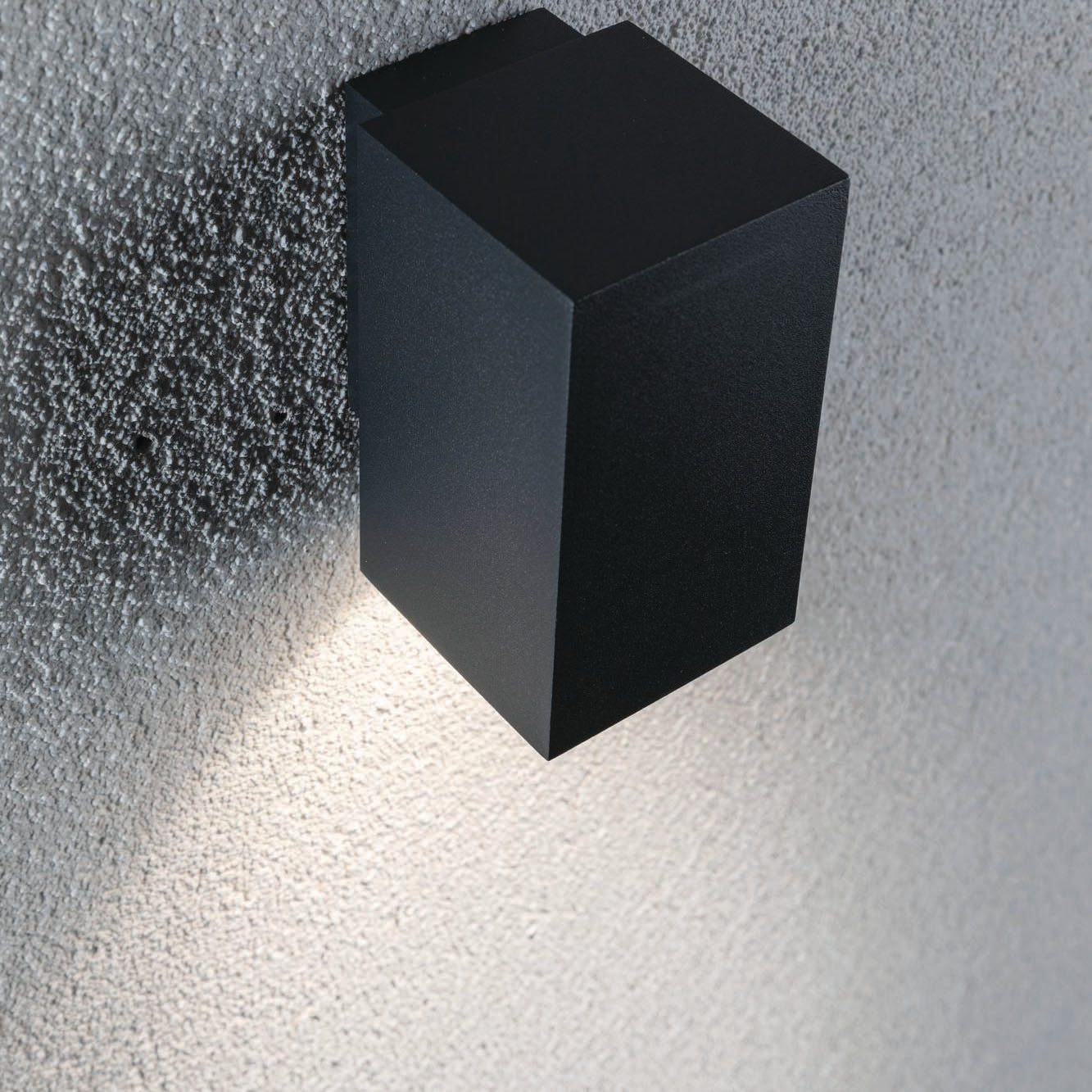 The Paulmann Outdoor Flame 5.2W LED Single Output Wall Light in Anthracite emits light onto a textured gray wall.