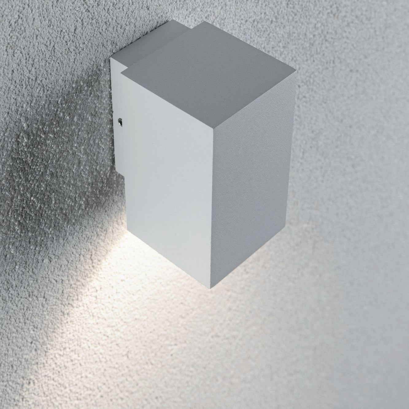 The Outdoor Flame 5.2W LED Single Output Wall Light in White is a minimalist surface-mounted luminaire that casts a soft glow on textured surfaces, creating attractive lighting effects.