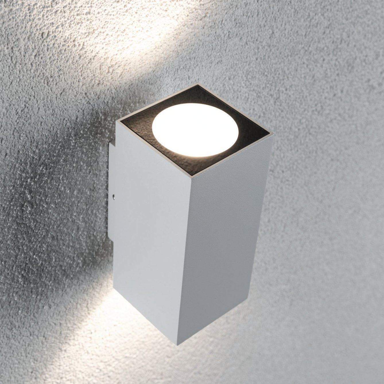 Outdoor Flame 6.6W LED Dual Output Wall Light in White, showcasing efficient LED technology and emitting light from both the top and bottom sides, creates attractive lighting effects on a textured wall with its modern square design.