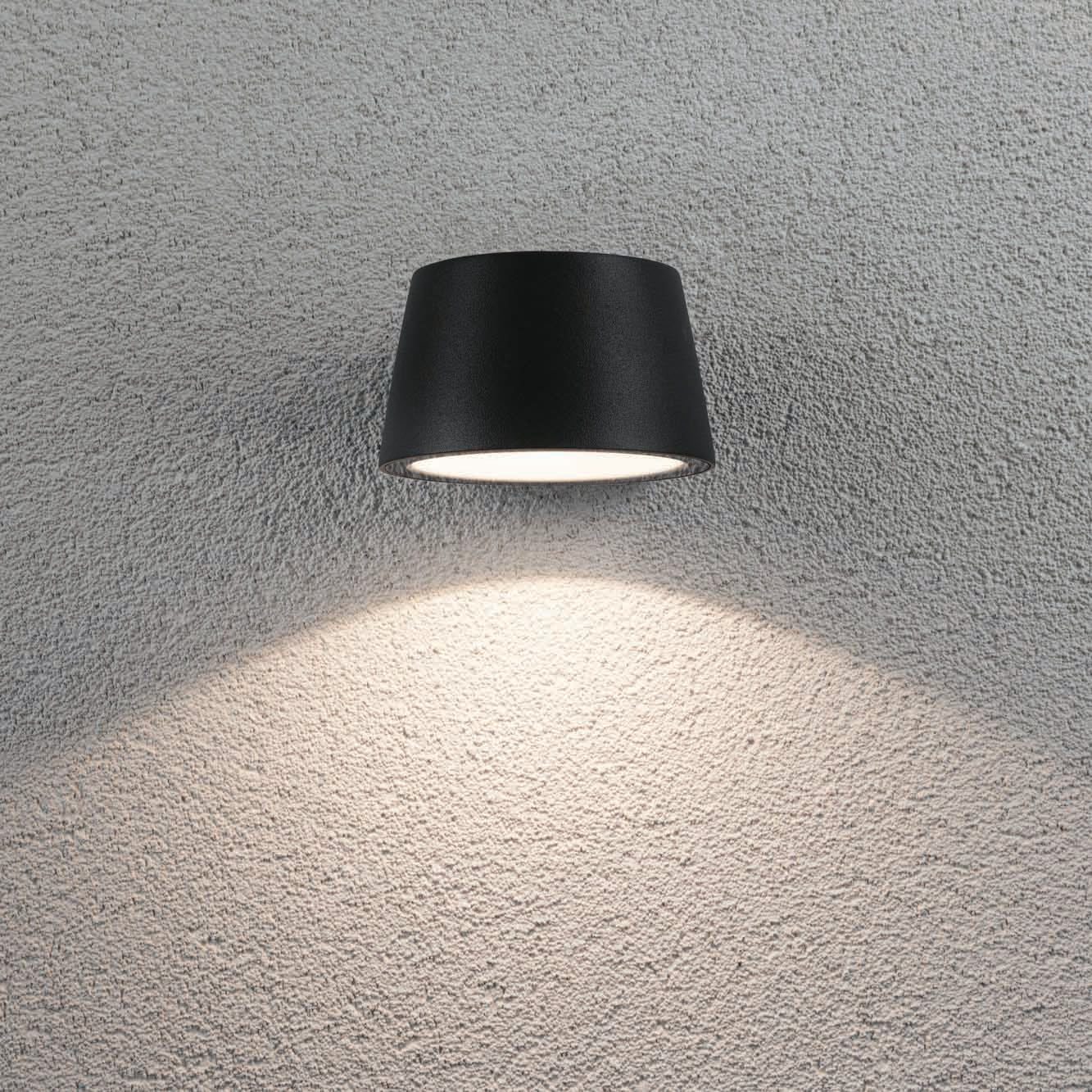 The Paulmann Outdoor Capea 8W LED Wall Light in Anthracite enhances a textured white surface with its sophisticated upward and downward illumination. Perfect for exterior walls, this anthracite fixture features an IP44 rating, guaranteeing both durability and style in all weather conditions.