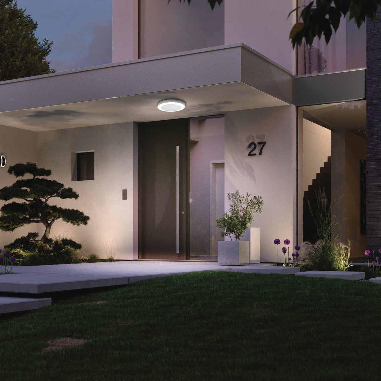 A contemporary house exterior showcasing a minimalist design, highlighted by the Paulmann Outdoor Circula Dusk 15W LED Ceiling Light with Motion Detection in White, illuminating the entrance. The number 27 is prominently displayed, accompanied by a landscaped front yard at dusk.