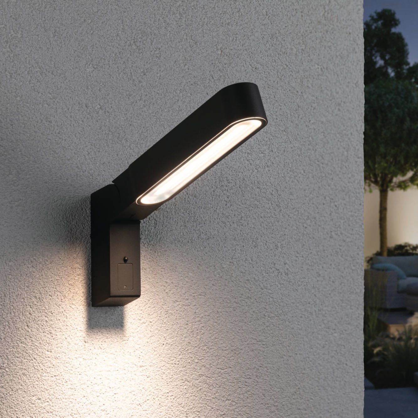 The Paulmann Outdoor Ito 7.5W LED Vertical Wall Light in anthracite, equipped with motion detection and IP44 splash protection, is mounted on a textured white wall, providing illumination for the exterior.