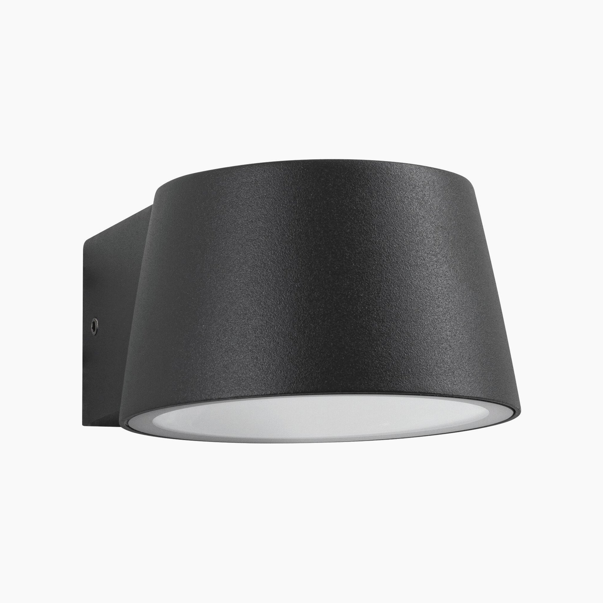 The Outdoor Capea 8W LED Wall Light with Insect Friendly in Anthracite features a modern cylindrical shade and a frosted glass diffuser, mounted on a square base, emitting a warm gold light.