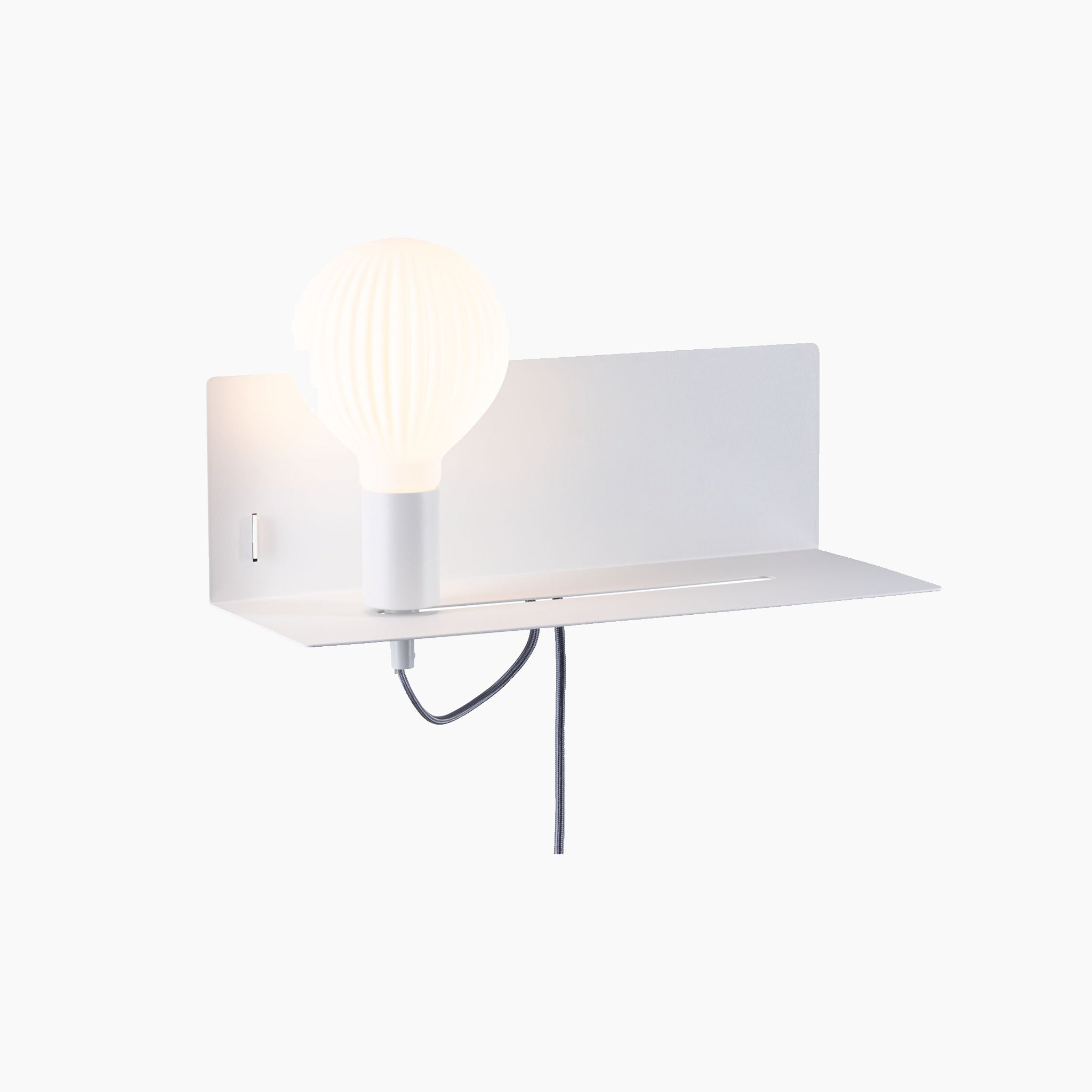 The Devara 40W Wall Mounted Lamp with USB Port in White Matt is a modern luminaire designed for reading, featuring an integrated shelf, a built-in light bulb, and a black power cord hanging below.