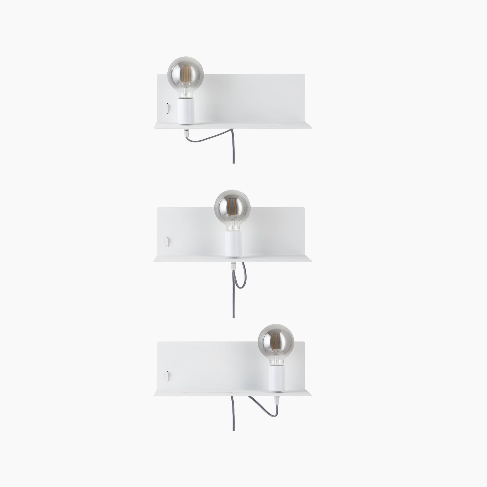 Three Devara 40W Wall Mounted Lamps with USB Ports in White Matt, each featuring an integrated shelf and light bulb, connected by metal conduits leading to the bottom shelf.