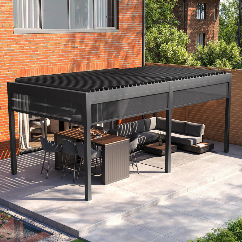 Explore a contemporary patio with the PergoSTET Deluxe 3m x 6m pergola, featuring motorised LED louvres and grey manual side blinds. Enjoy seating, a dining table, and brick walls framed by lush greenery.