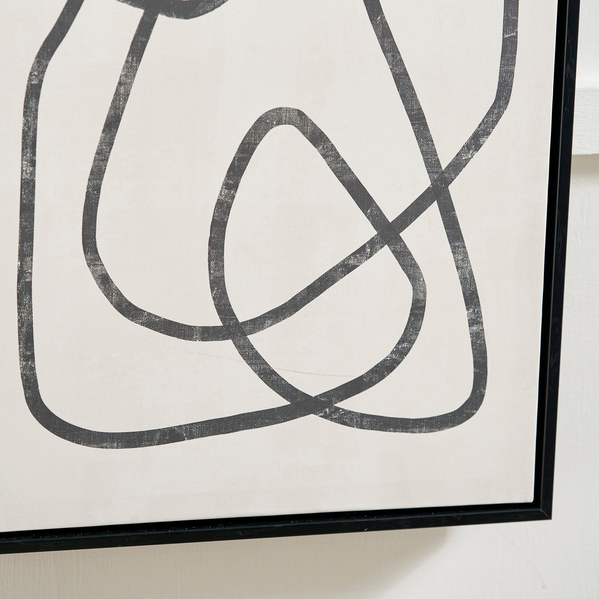 The Black Squiggle Print Canvases with Black Frames bring a bold, monochrome design to any interior decor setting, featuring abstract line art on a white canvas.