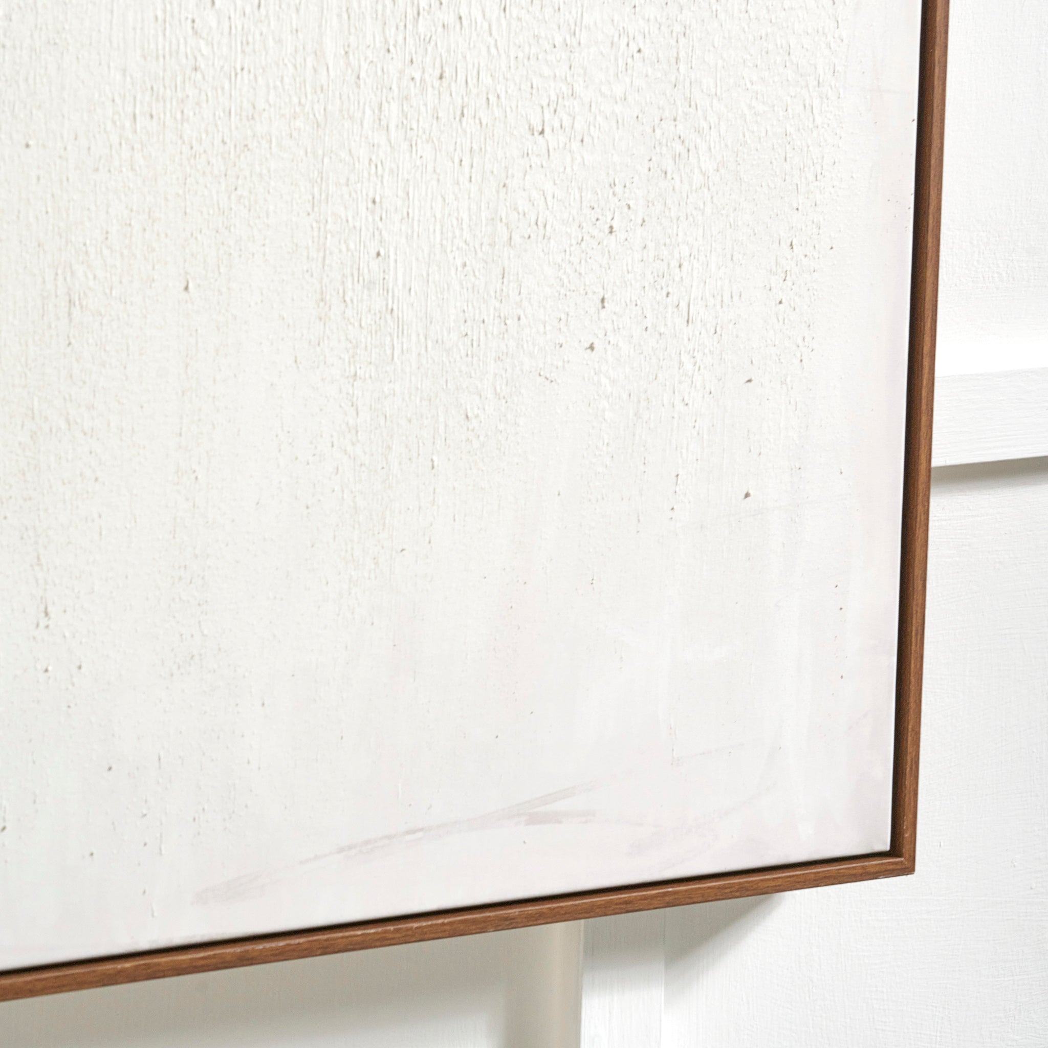 Close-up of the Natural and White Abstract Canvas with Natural Frame Large, its textured white surface enhancing the minimalist charm as it hangs on a white wall.