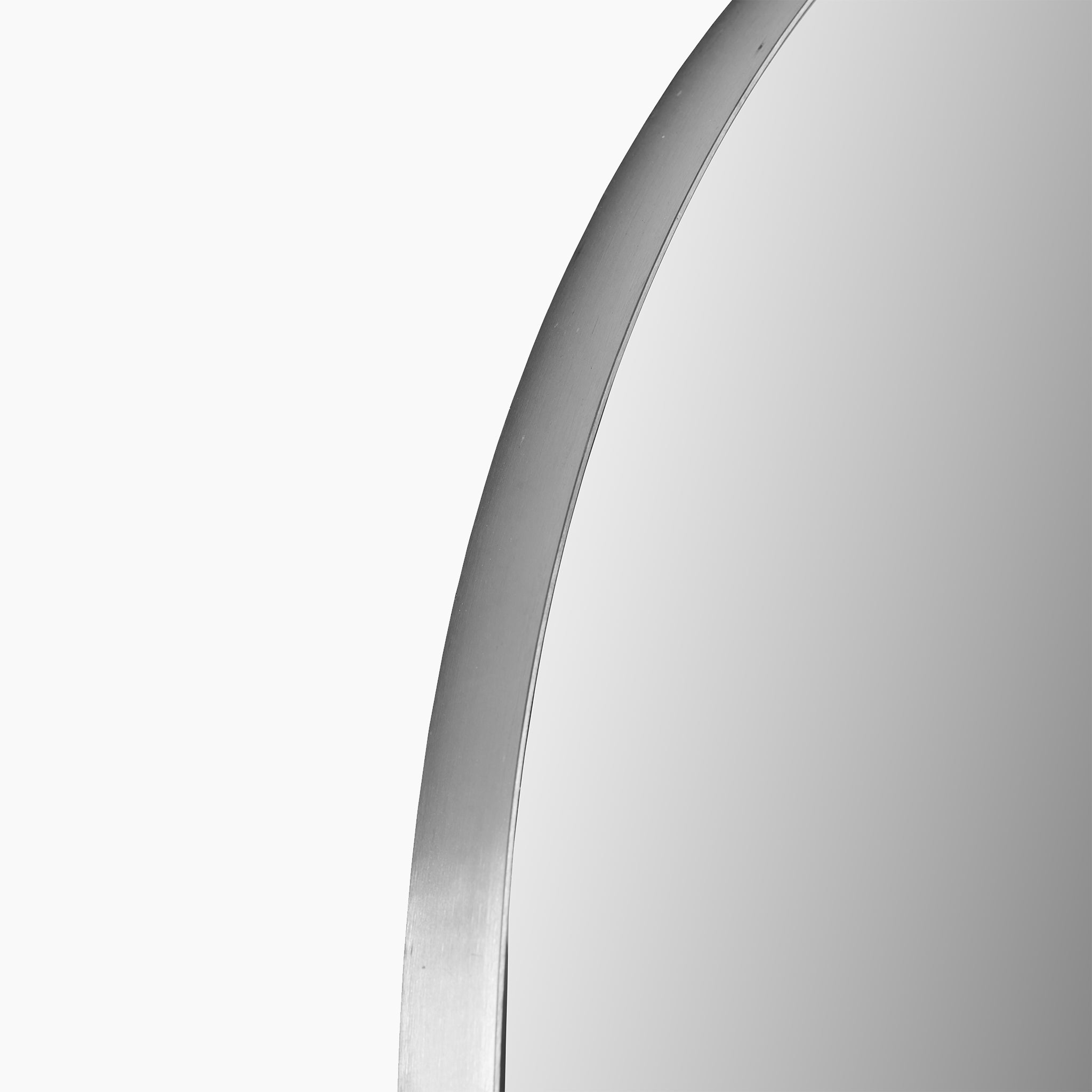 Close-up of the Brushed Silver Metal Slim Frame Arch Floor Mirror, highlighting a segment of its sleek edge against a white background, perfect for adding an element of minimalist decor to your space.