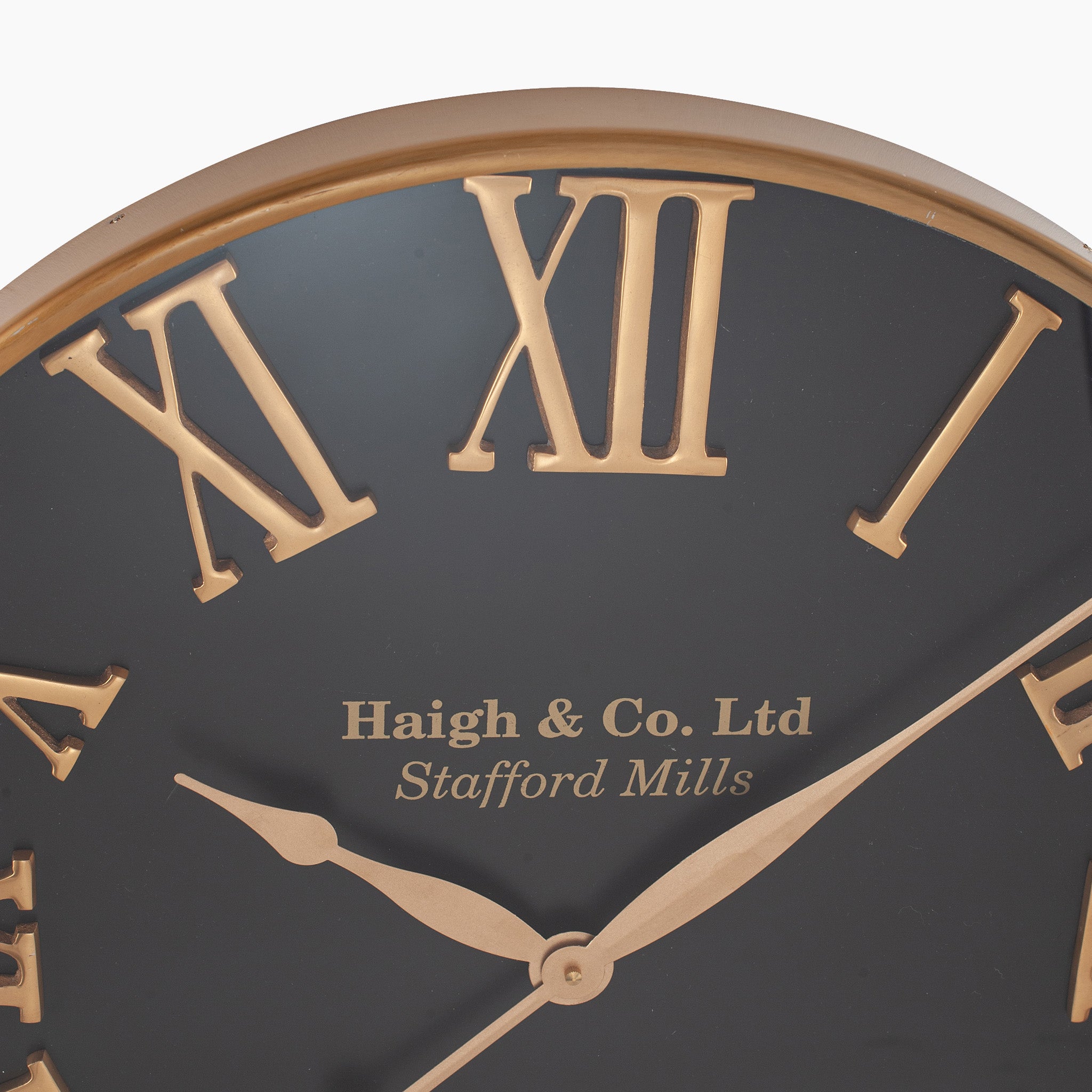 Close-up view of the Antique Gold and Black Metal Wall Clock, featuring oversized Roman numerals and the inscription "Haigh & Co. Ltd, Stafford Mills," ideal for adding a touch of elegance to contemporary interiors.