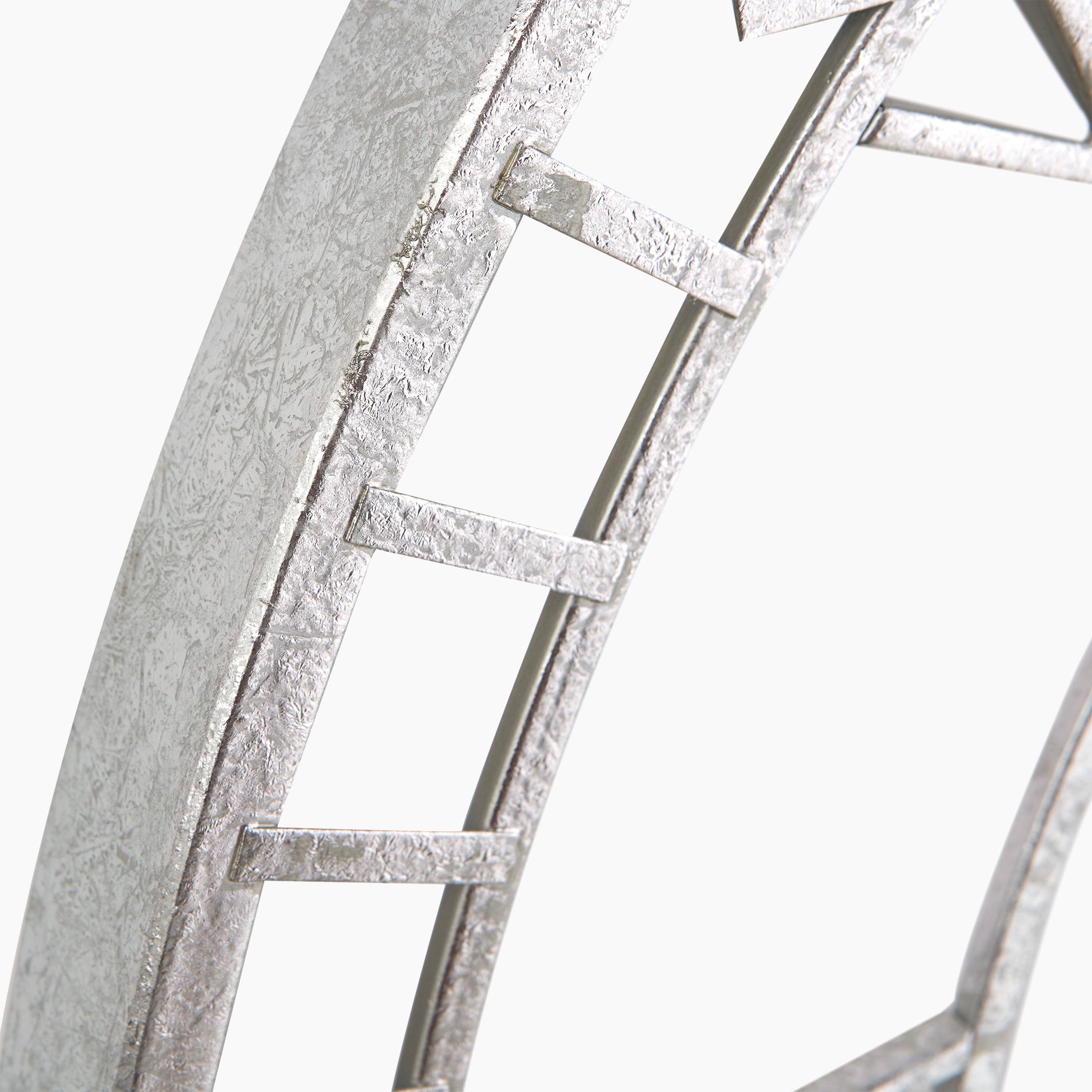 Close-up of a textured, abstract sculpture with ladder-like elements on a curved structure reminiscent of the Antique Silver Metal Round Wall Clock Large.