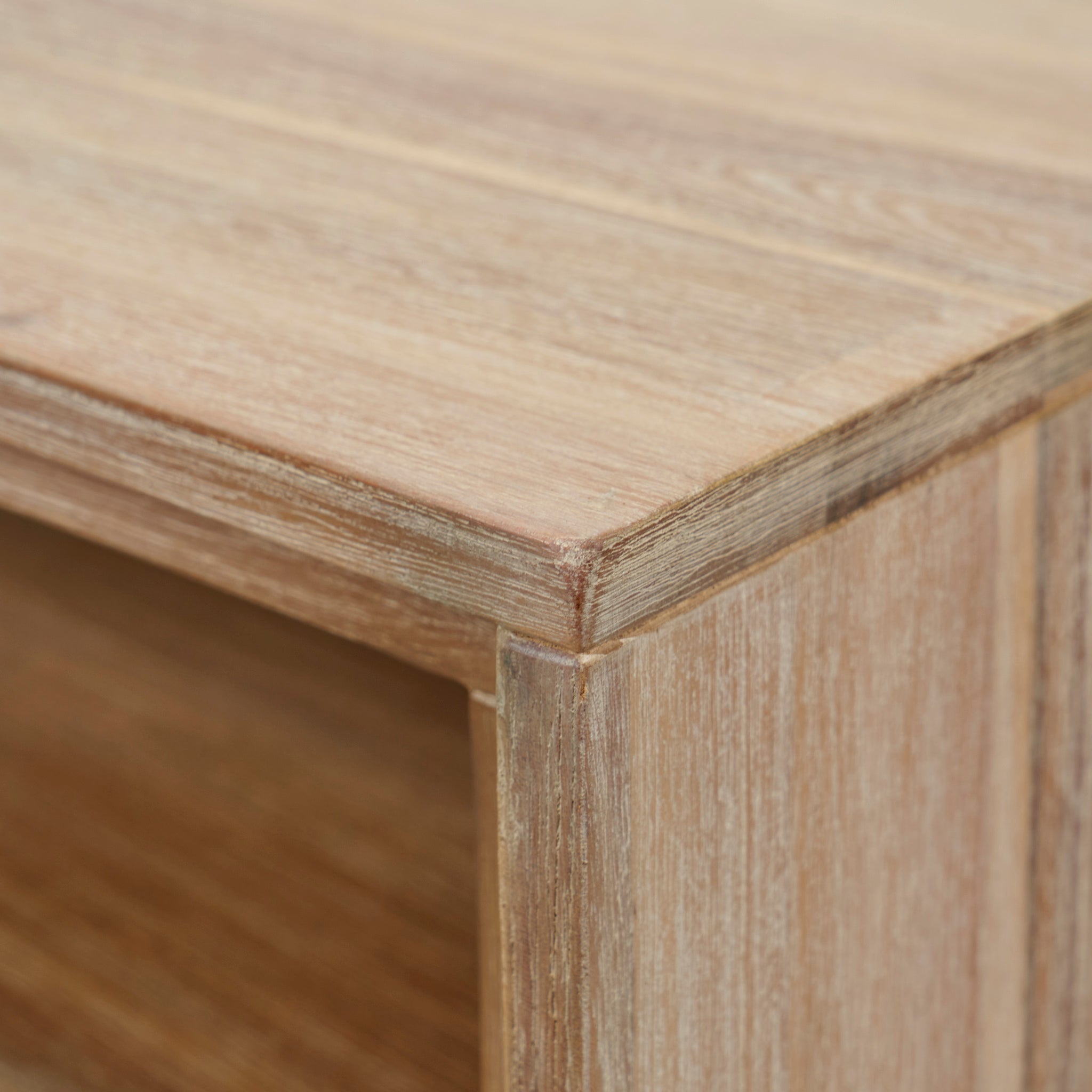 Close-up of the Marca Sand Wash Acacia Wood and Black Metal Bedside Unit corner, showcasing the texture and grain of the light-colored wood, reminiscent of Scandi-style design perfect for a bedside unit.