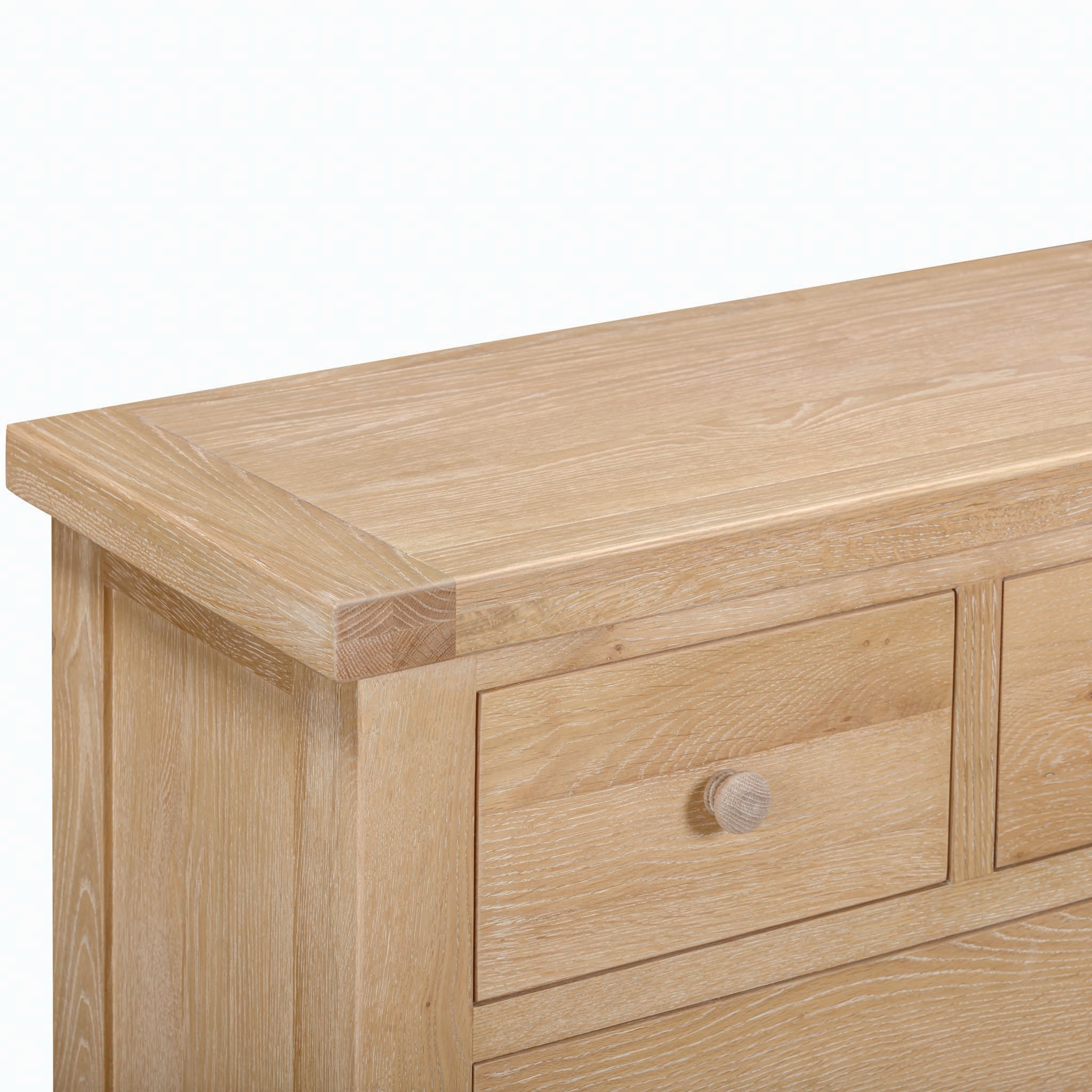 Close-up of the Burford 2 Over 3 Chest of Drawers in Natural Oak, showcasing the corner detail and part of a drawer with a round knob, exemplifying ample storage solutions.