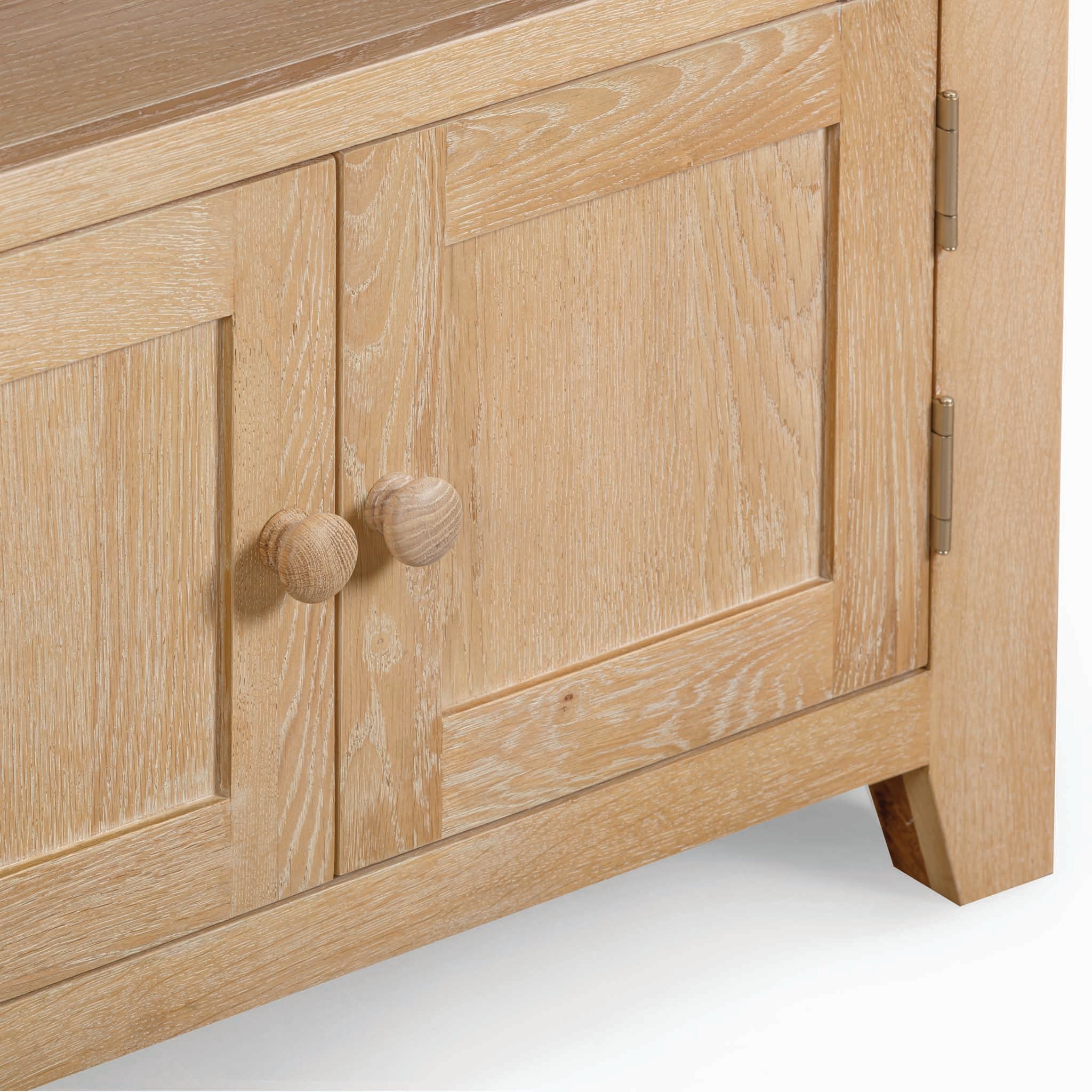 Close-up of natural oak cabinet doors with round handles and visible wood grain, part of the Burford Corner Media Unit in Natural Oak, exuding rustic charm.