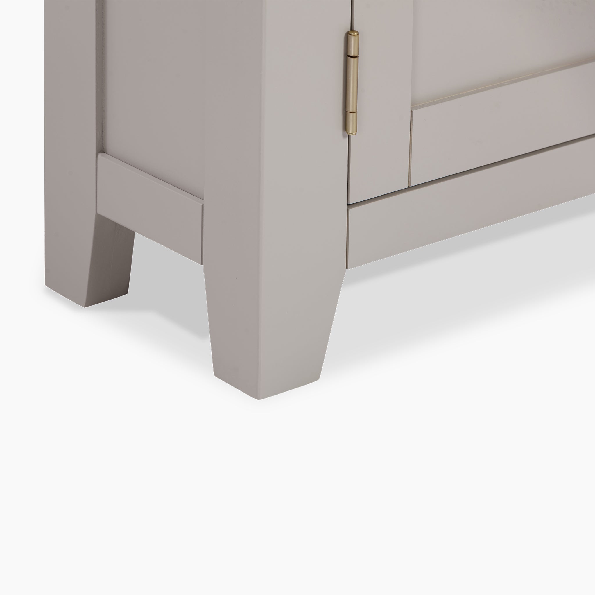 Close-up of the Burford Corner Media Unit in Pebble Grey, featuring a brass hinge and angled legs against a white background, highlighting its rustic charm.