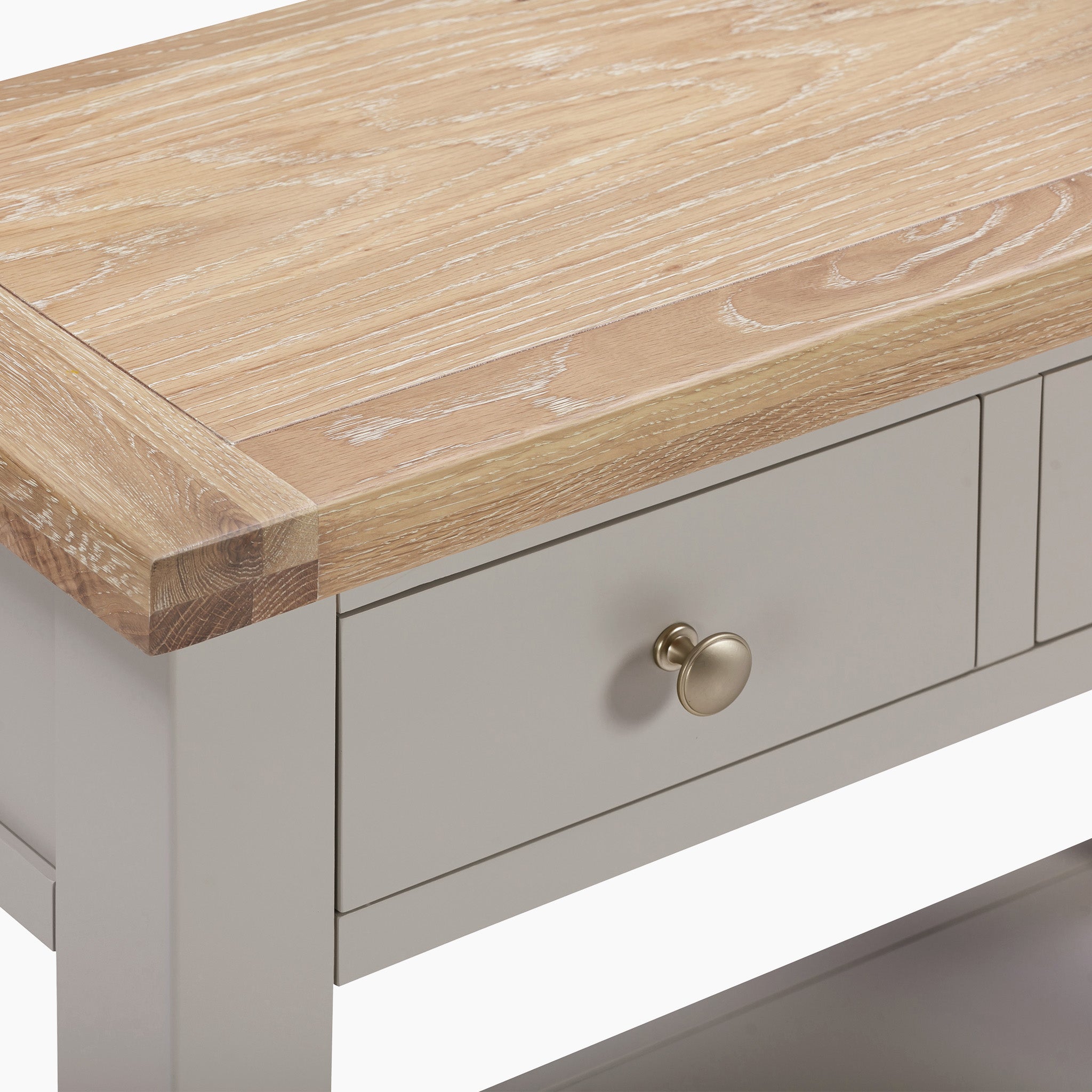 The Burford 2 Drawers Console Table in Pebble Grey features a natural oak finish with a light brown top and elegant drawers, each adorned with a round metallic knob.