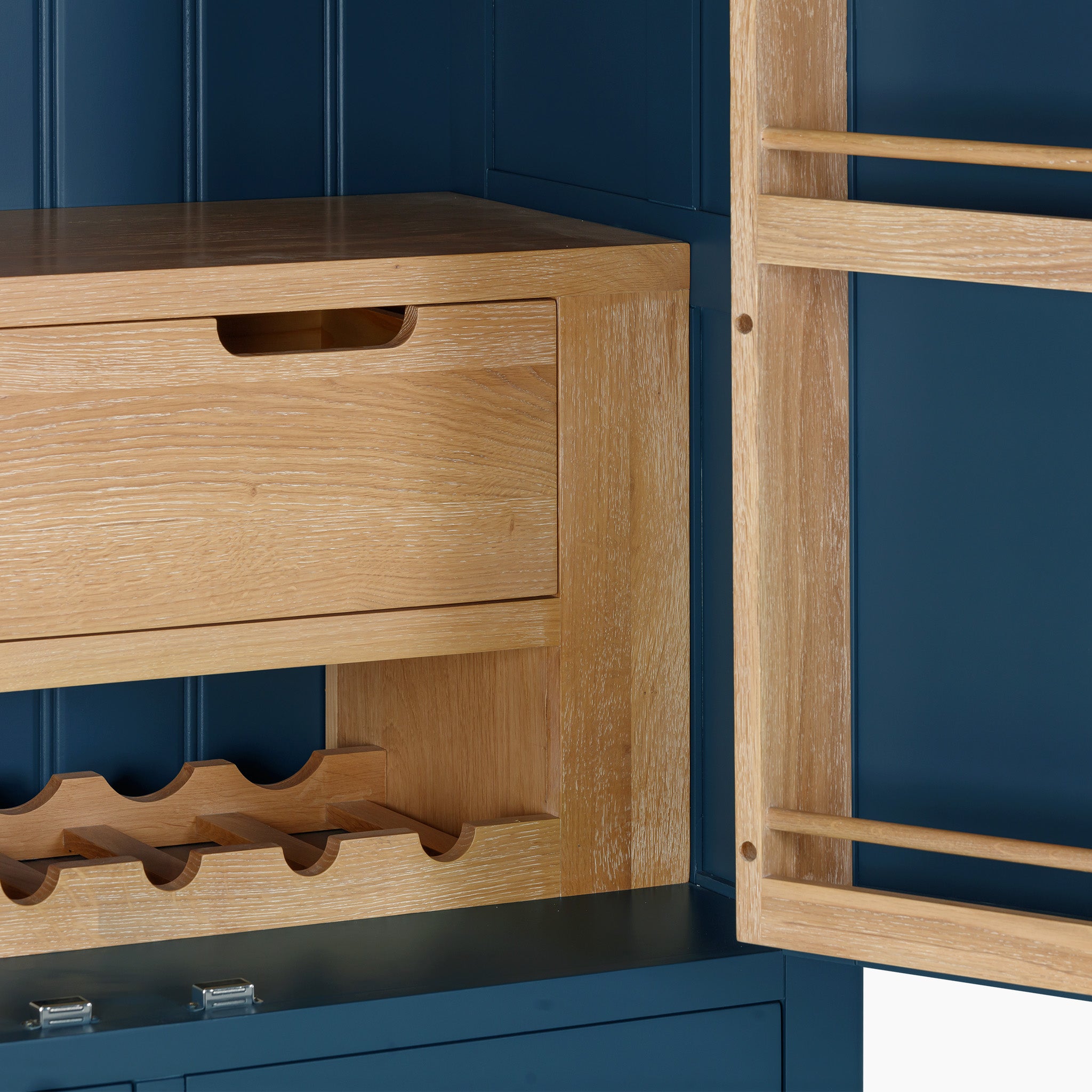 The Burford Double Larder Unit in Navy Blue is a striking wooden cabinet, featuring a built-in wine rack and drawer, all beautifully framed by its navy blue interior.