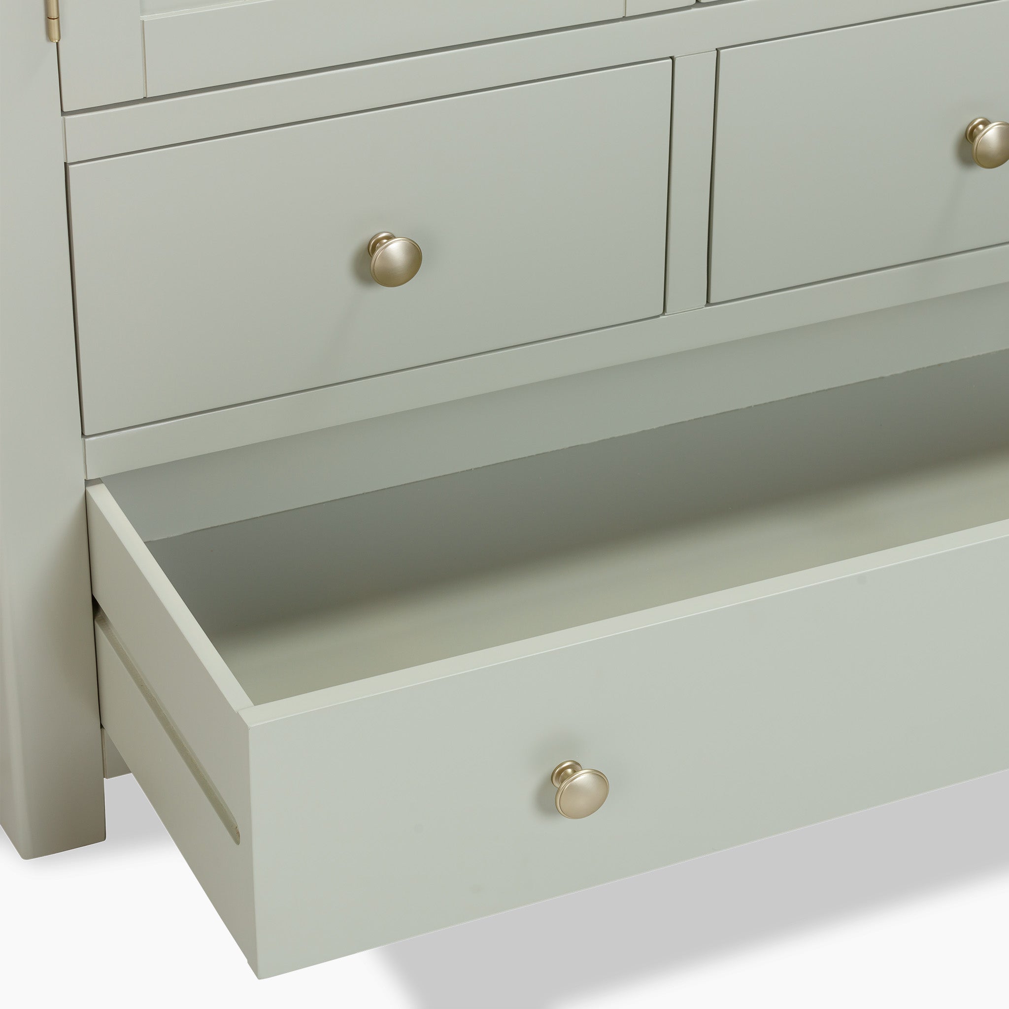 A sage green dresser with four drawers, one slightly ajar, showcasing round knobs. The natural oak accents lend it a timeless charm similar to the elegant Burford Double Larder Unit in Sage Green.