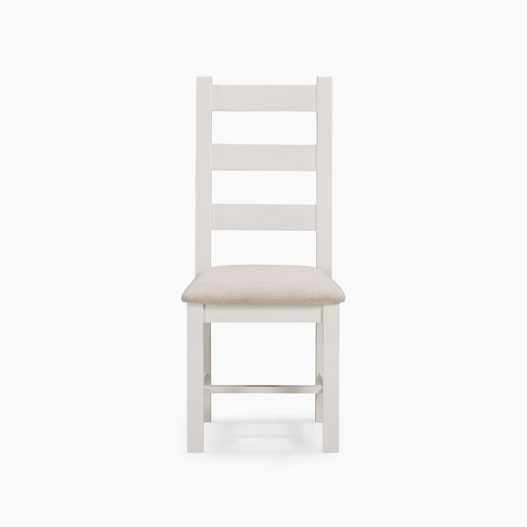 The Burford Set of 2 Ladderback Dining Chairs in Warm White showcases a charming white wooden frame, highlighted by a ladder back design and topped with a beige cushioned seat. The natural oak accents complete the look, adding an elegant touch to the simple and stylish aesthetic.