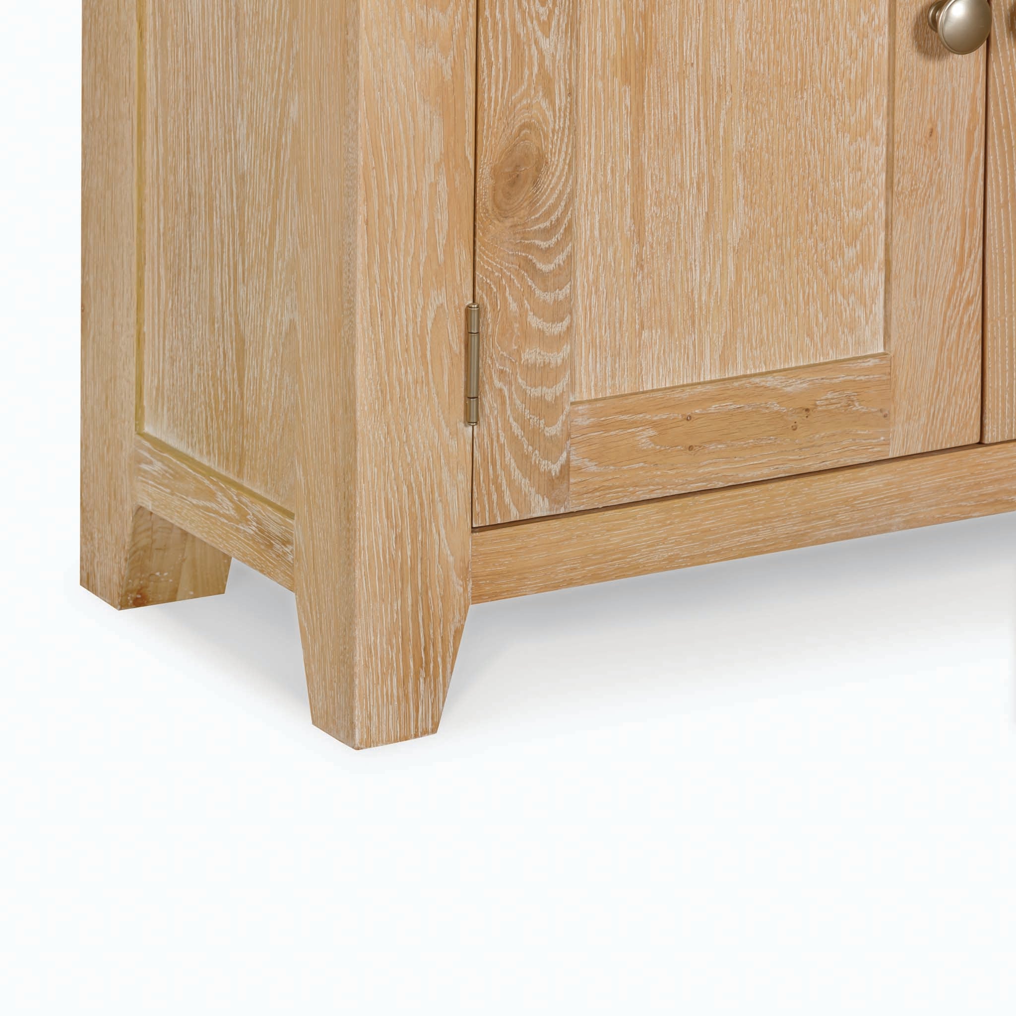 Close-up of the Burford Display Cabinet in Natural Oak corner with visible wood grain texture and a door hinge, showcasing its elegant craftsmanship.