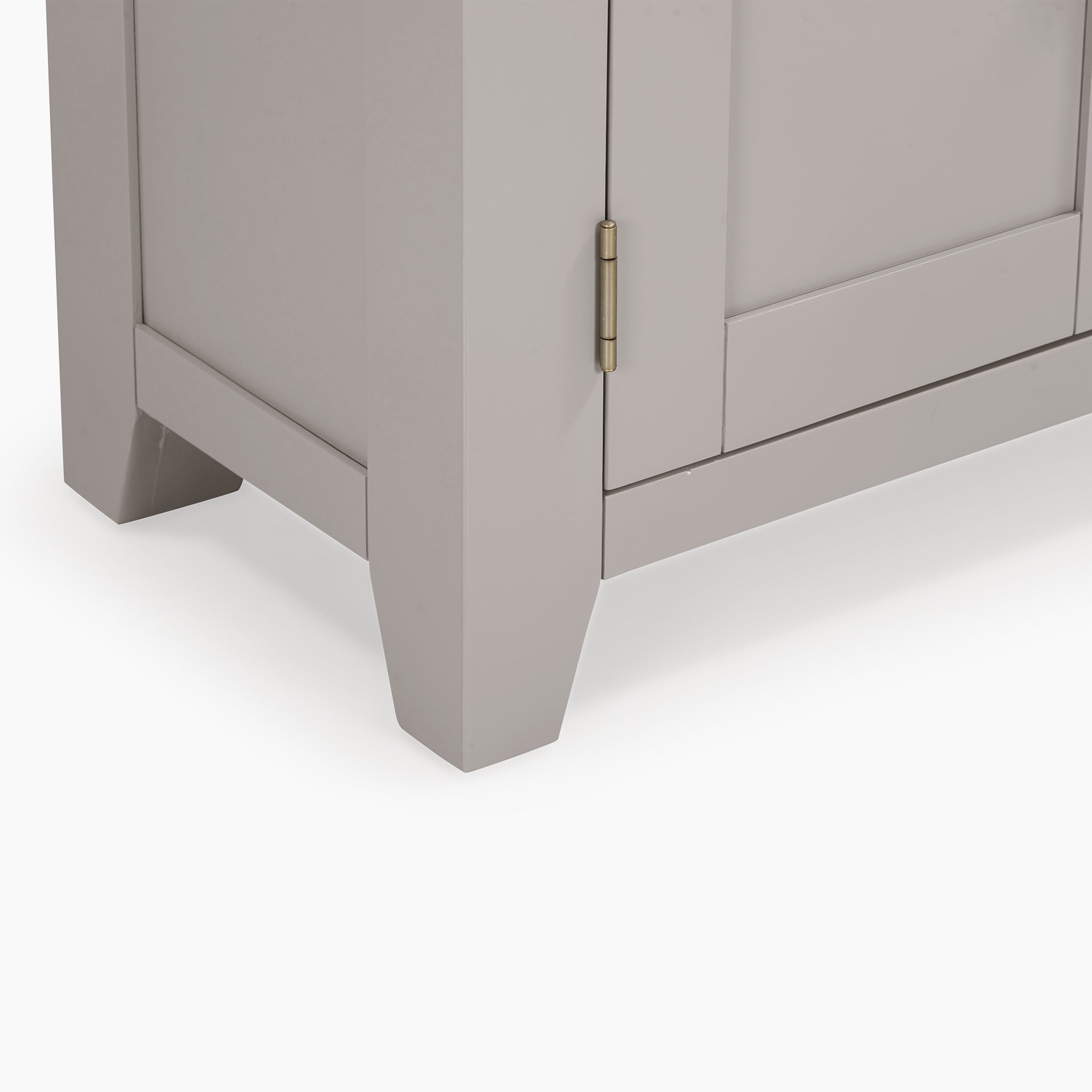 Close-up of the Burford Display Cabinet in Pebble Grey's corner highlights a pebble grey finish with a visible hinge and sturdy leg design, complementing its glass-panelled doors.