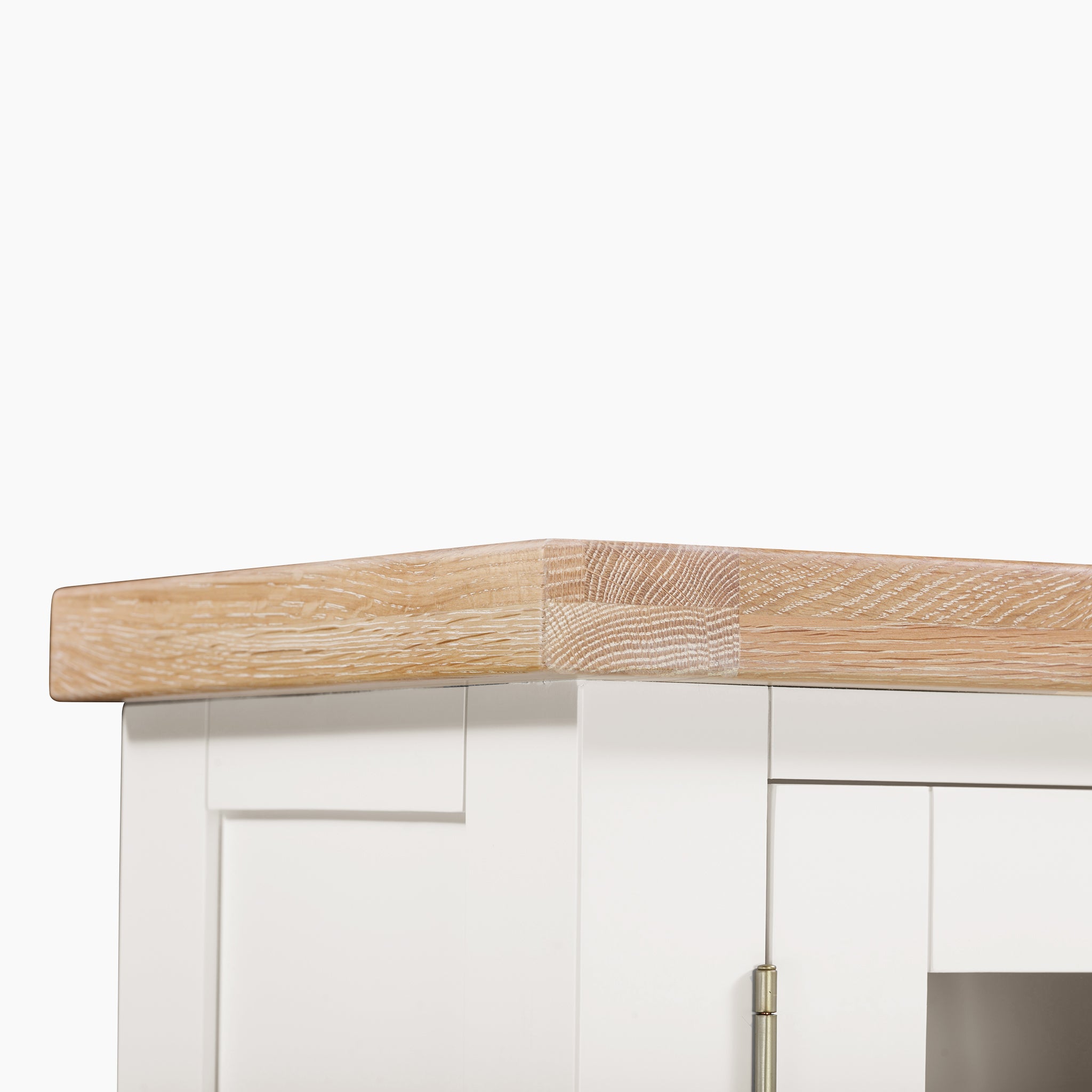 Close-up of a Burford Display Cabinet in Warm White with a light wood countertop against a plain background, showcasing its seamless blend with the environment.