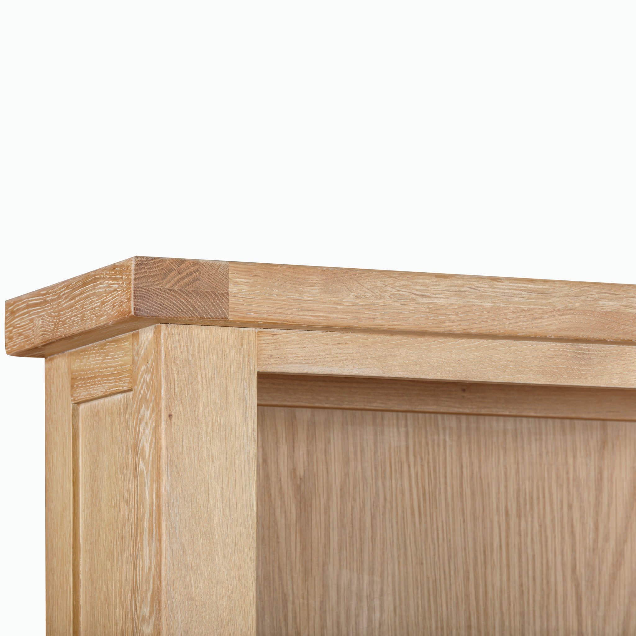 Close-up of the corner of the Burford Large Bookcase in Natural Oak, showcasing clean lines and smooth texture with a light finish, embodying contemporary elegance.