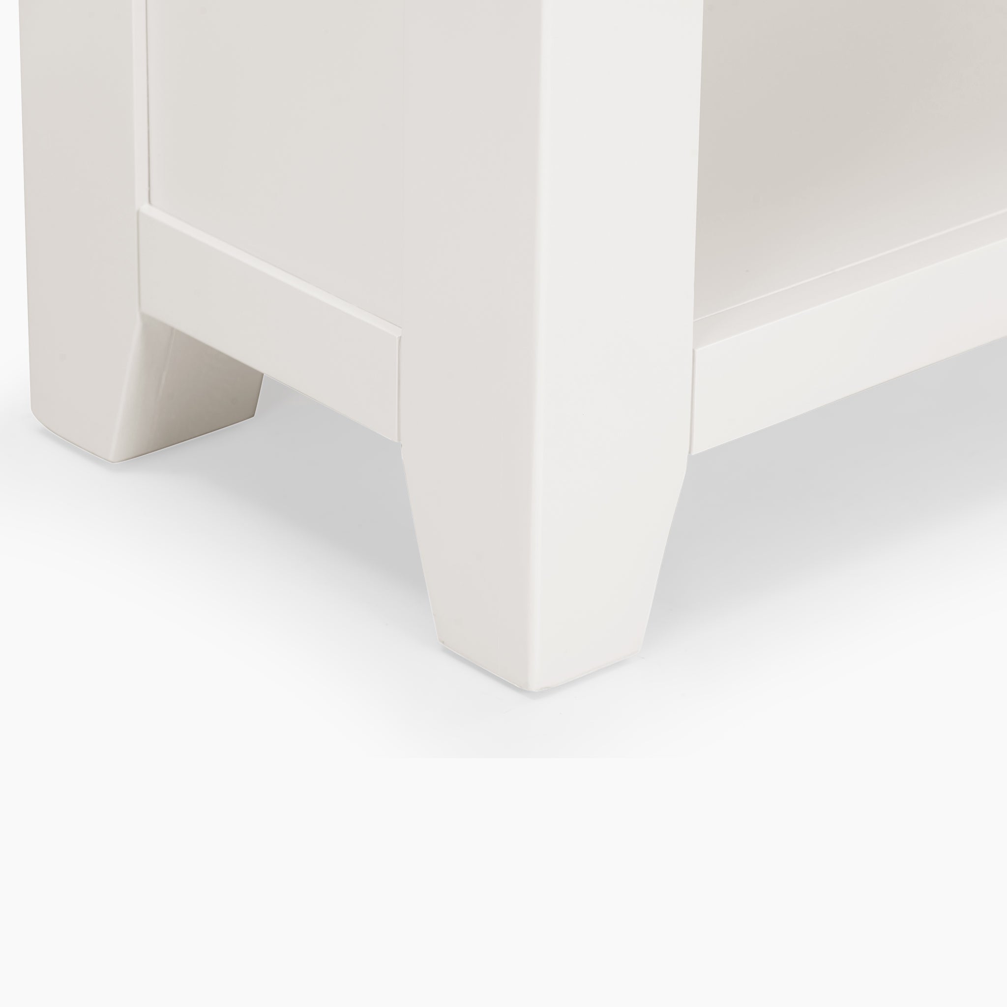 Close-up of a warm white furniture corner with a thick leg and subtle panel details, reminiscent of the Burford Large Bookcase in Warm White, on a light surface.