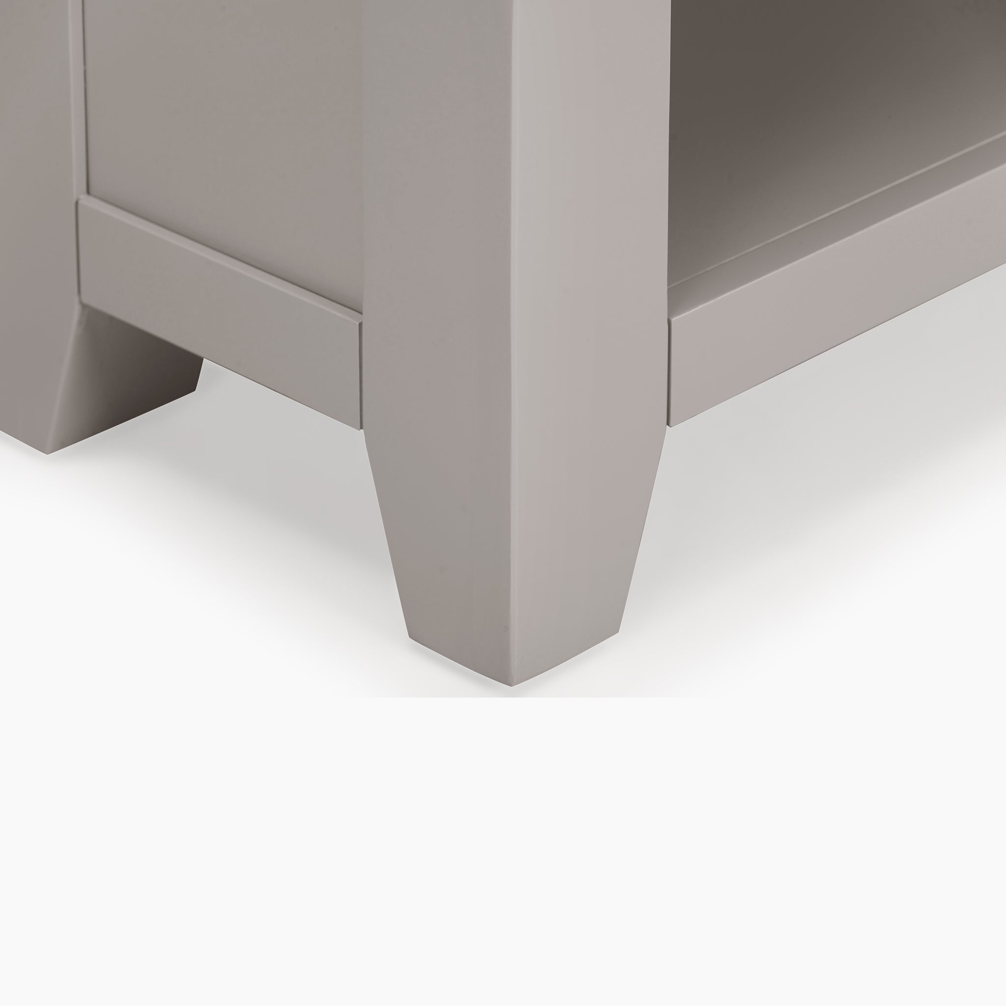 Close-up of a square and tapered wooden furniture leg in pebble grey from the Burford Large Coffee Table with Shelf, featuring hints of natural oak.